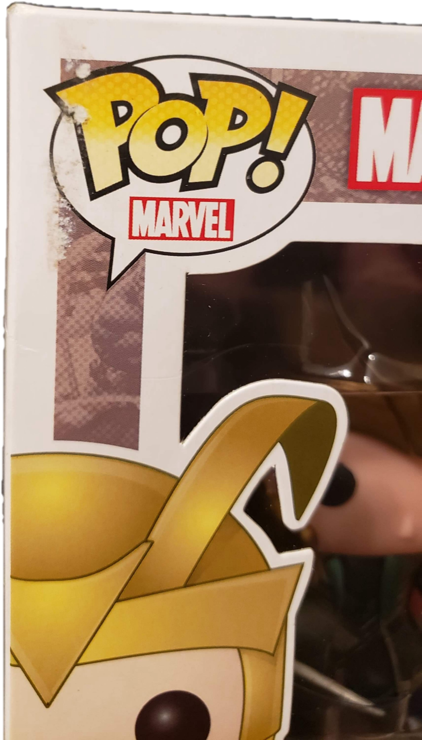 洛基 桌布 壁紙 — 近距離拍攝的Funko Pop! Marvel人偶，金色頭盔和黑色眼睛透過包裝可見。