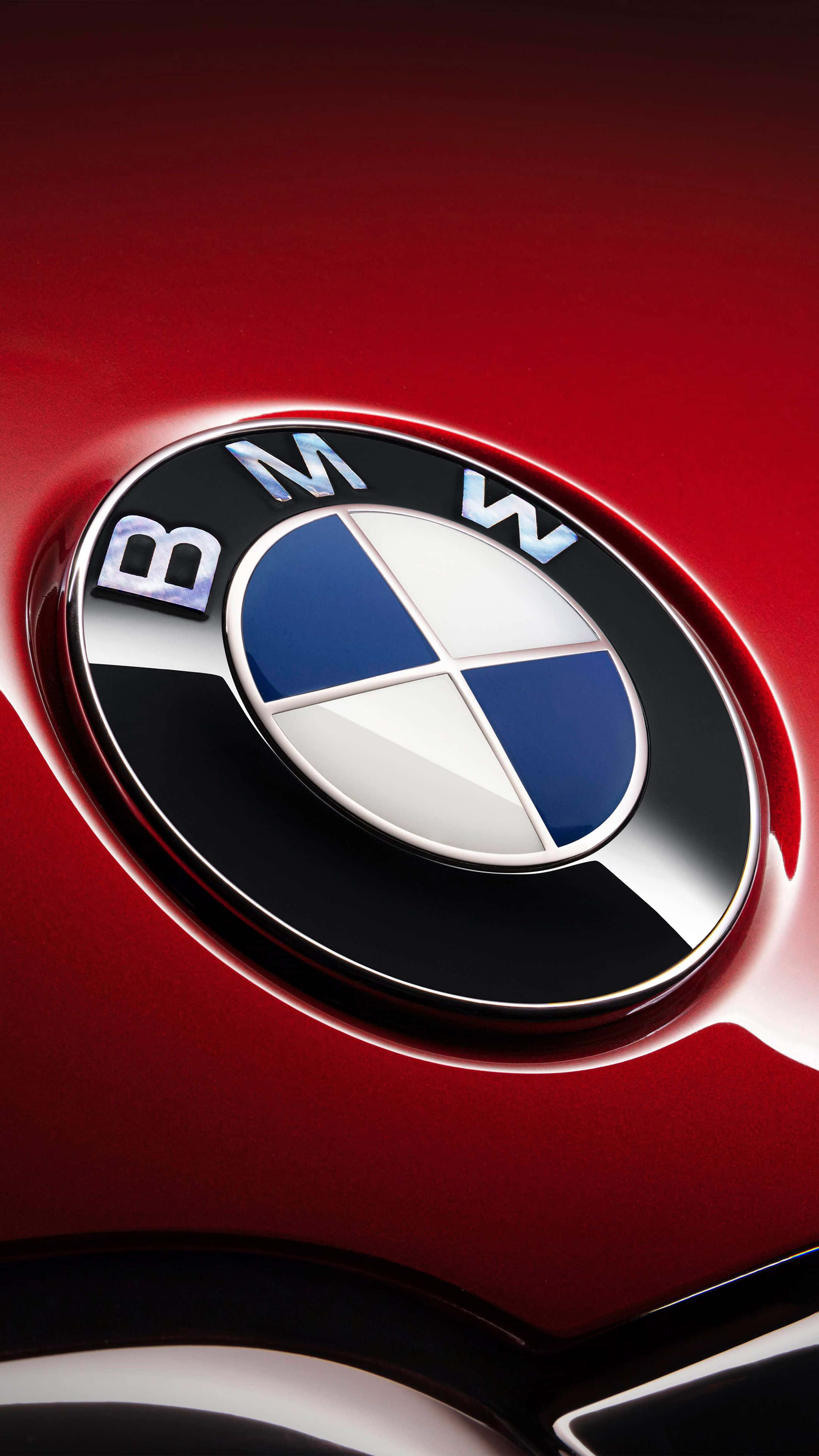 Bmw Android 桌布 壁紙 — 近距離拍攝的亮面紅色BMW標誌，帶有藍白相間的區域，反射出攝影棚燈光。