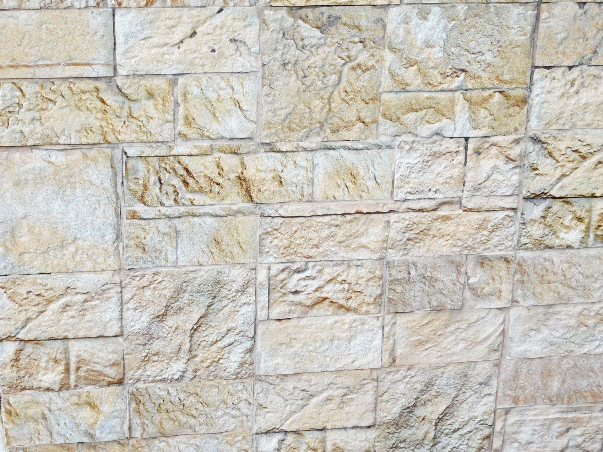 Stone texture 壁紙 — 近距離拍攝的紋理石牆，不規則的米色和奶油色塊以鄉村風格排列。