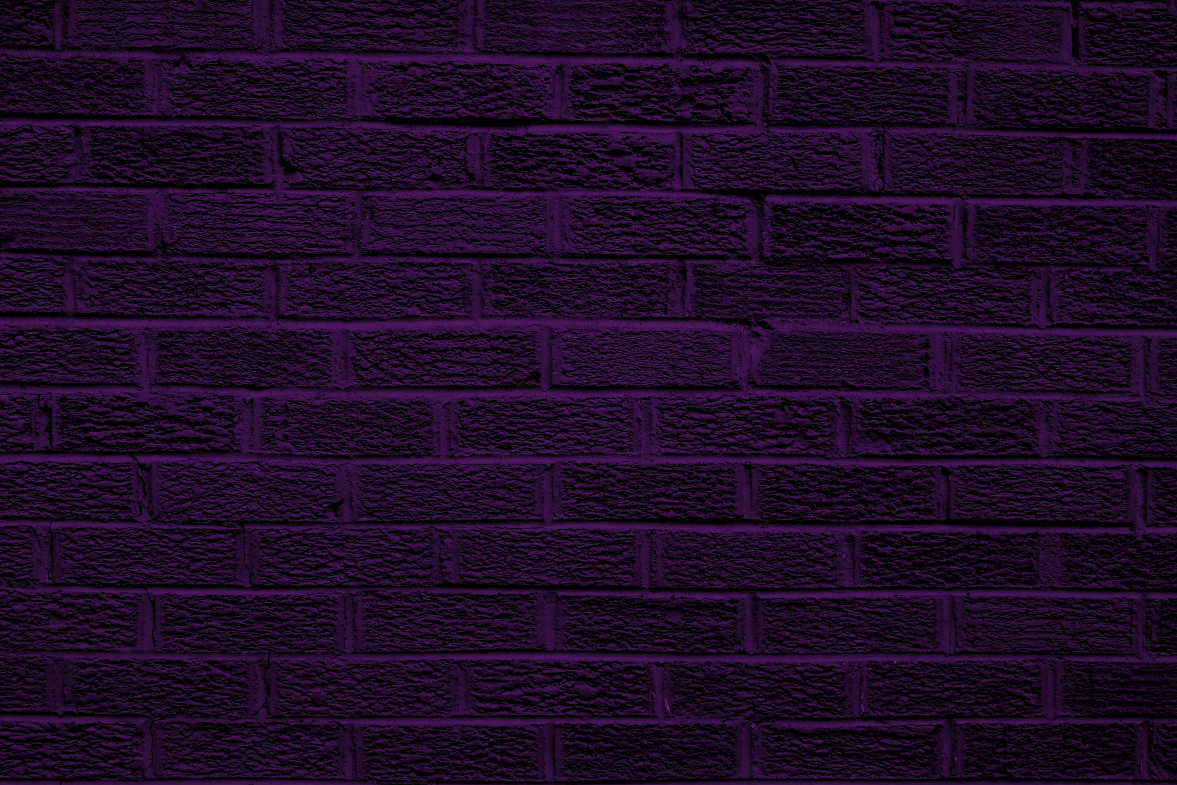 Dark Purple 桌布 壁紙 — 近距離拍攝的紋理磚牆，塗上深紫色，帶有微妙的燈光變化。