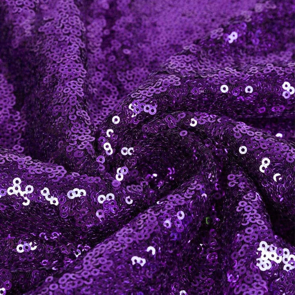 Purple Sequins 桌布 壁紙 — 近距離拍攝的豐富紫色布料，覆蓋著閃爍的亮片，在褶皺中捕捉光線。