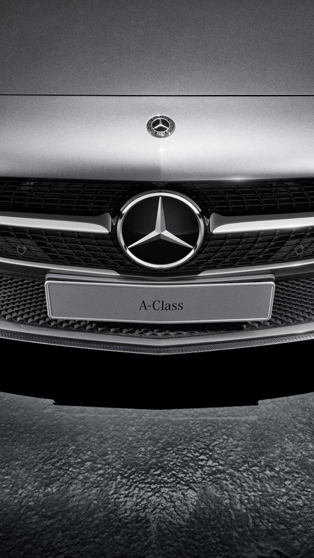 iPhone X Mercedes 桌布 壁紙 — 近距離拍攝銀色賓士A-Class的時尚水箱護罩，帶有鍍鉻飾邊和下方紋理地面。