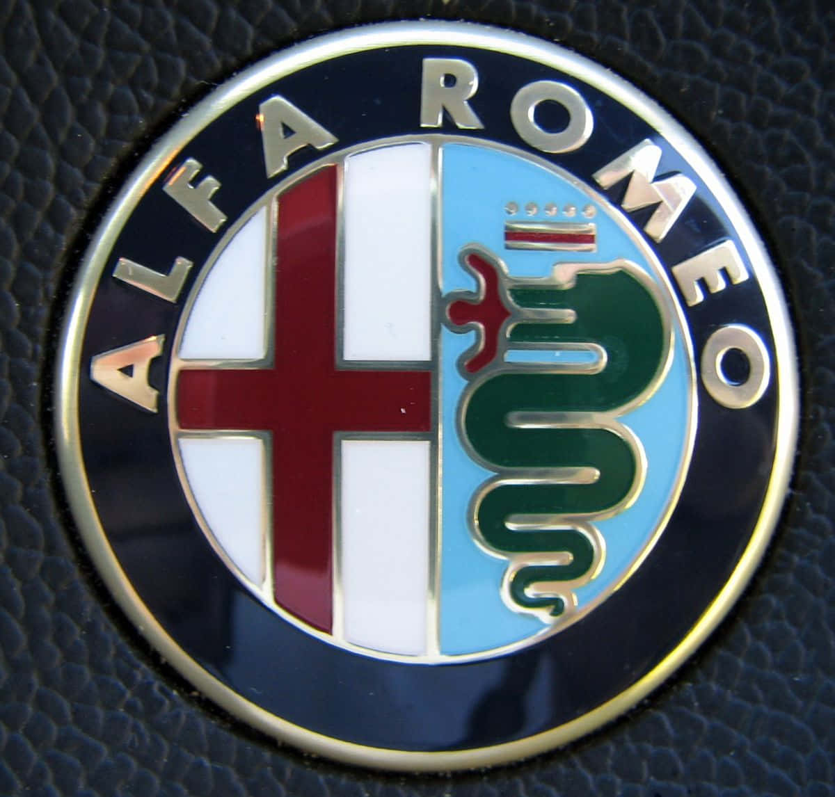 愛快羅密歐 桌布 壁紙 — 近距離拍攝閃亮的 Alfa Romeo 標誌，帶有紅色十字和綠色蛇，背景為藍色和白色。