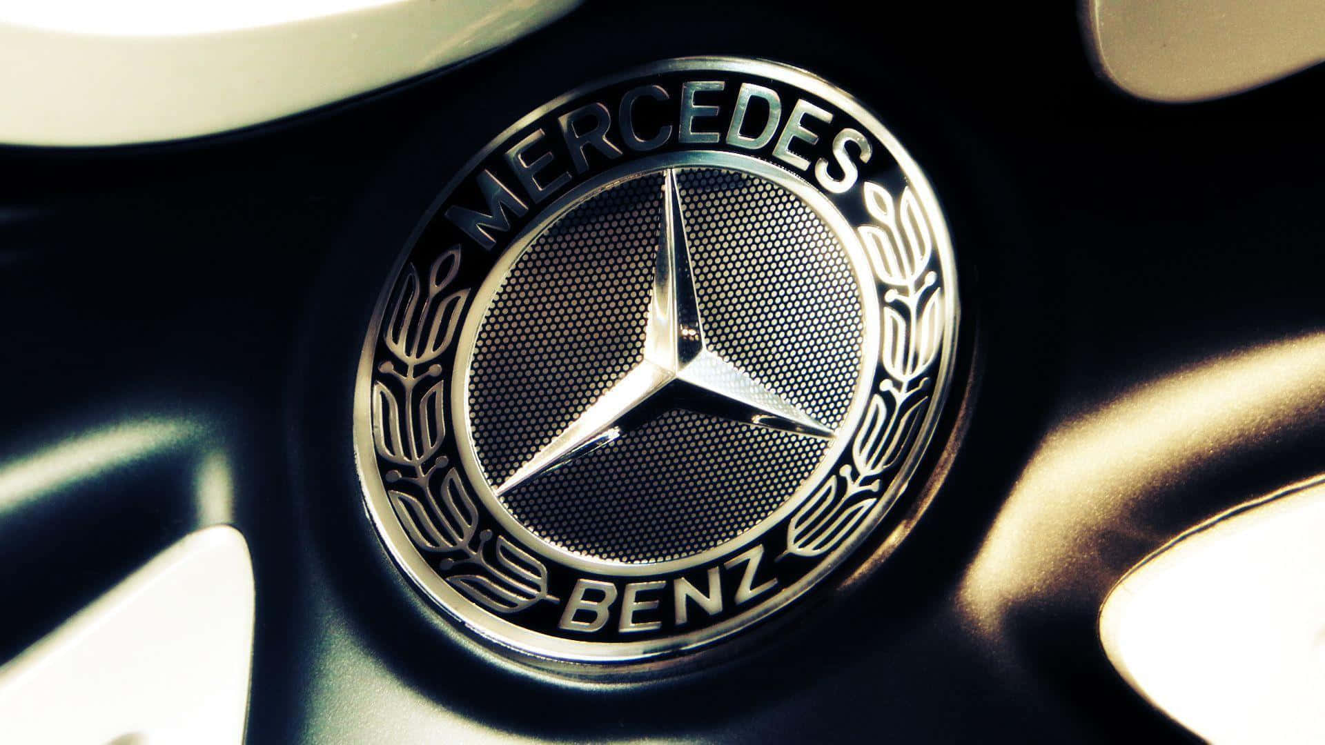 Mercedes Benz Logo 桌布 壁紙 — 近距離拍攝閃亮的 Mercedes-Benz 標誌在汽車輪圈上，溫暖的燈光突顯金屬細節。
