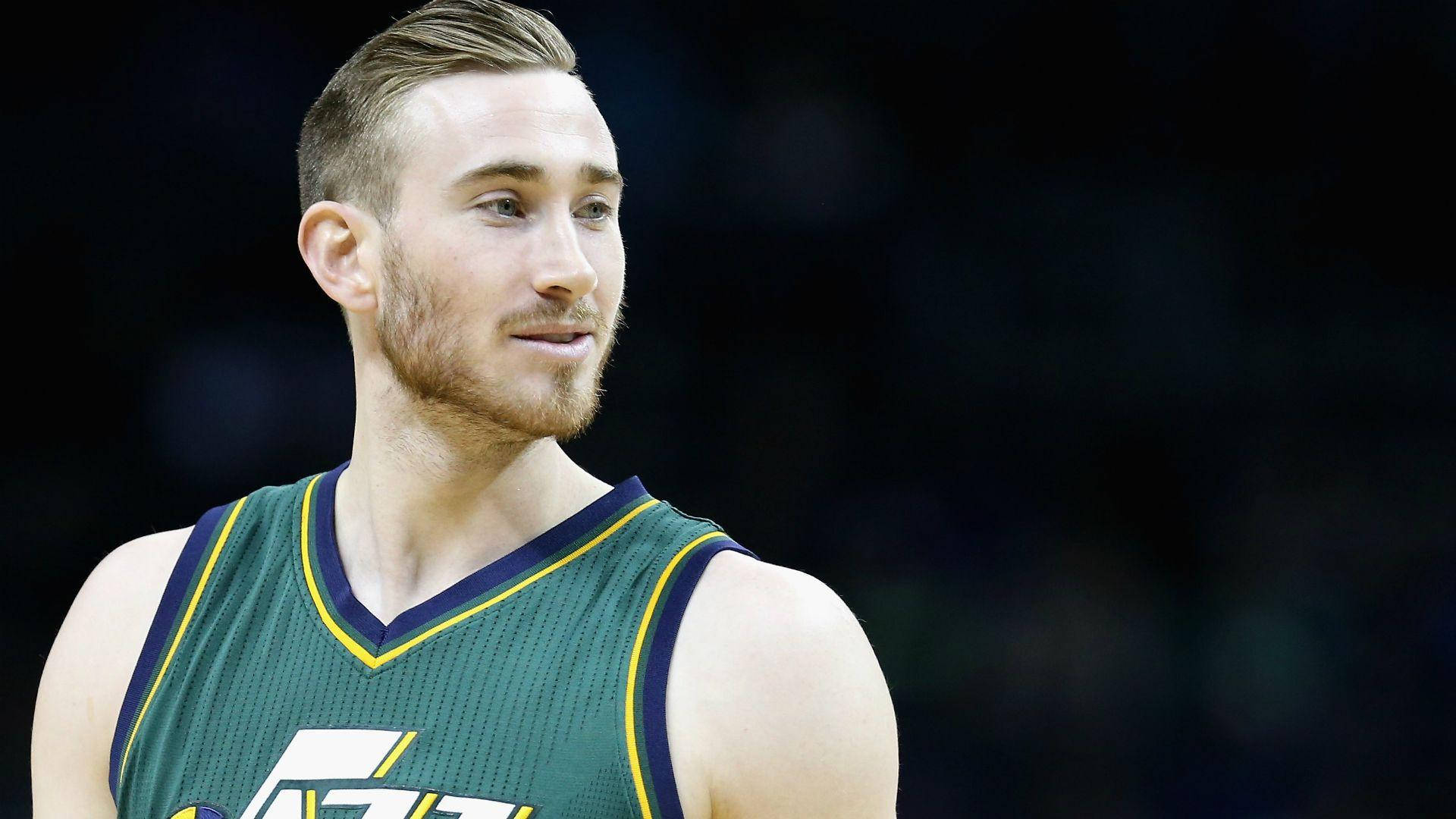 gordon hayward 桌布 壁紙 — 近距離肖像，一名留鬍鬚的籃球運動員身穿綠色和黃色球衣，背景為深色模糊。