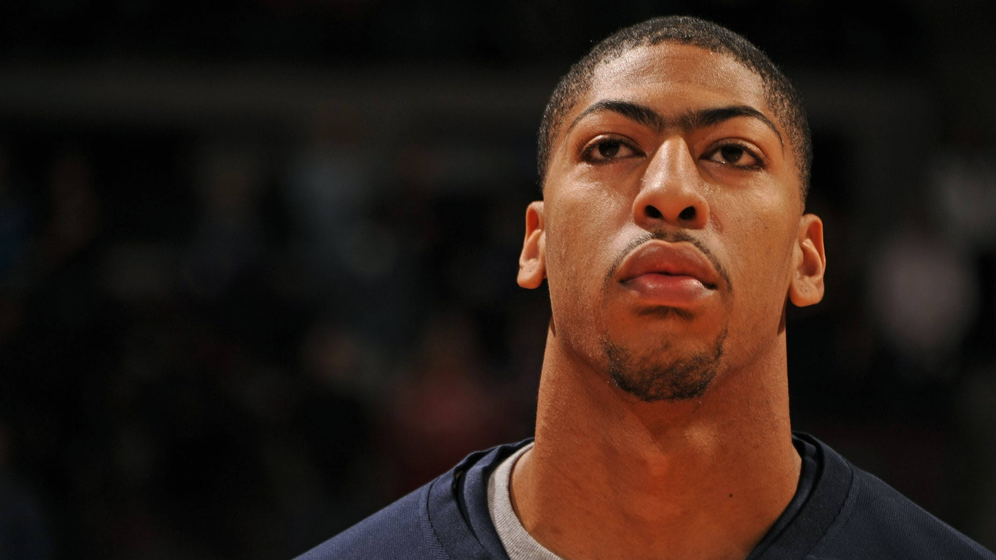 Anthony Davis 桌布 壁紙 — 近距離肖像，專注的籃球運動員，眼神強烈，背景模糊的競技場。