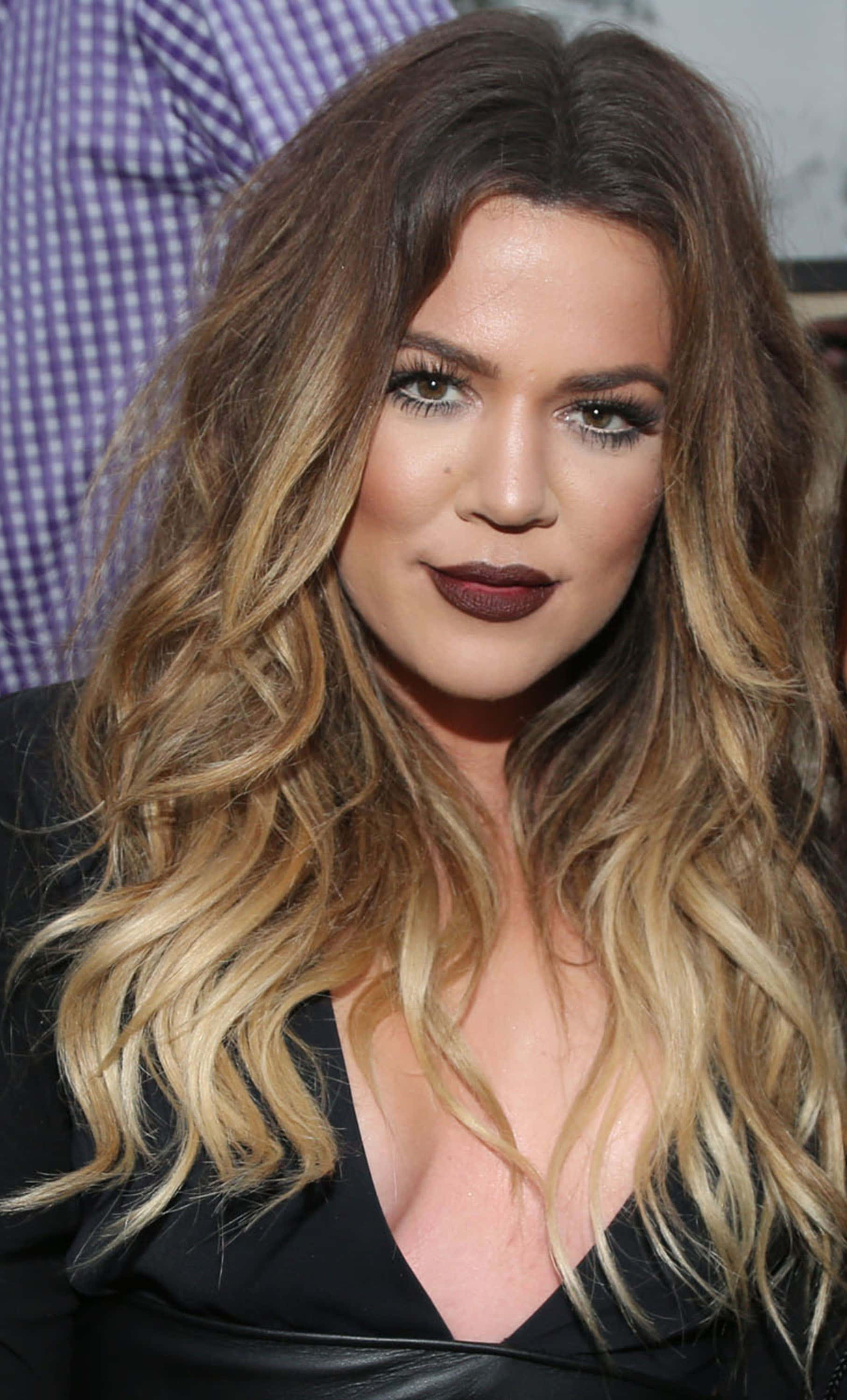 Khloe Kardashian 桌布 壁紙 — 近距離肖像照，一位擁有豐盈波浪金髮和鮮明深色唇膏的女性。