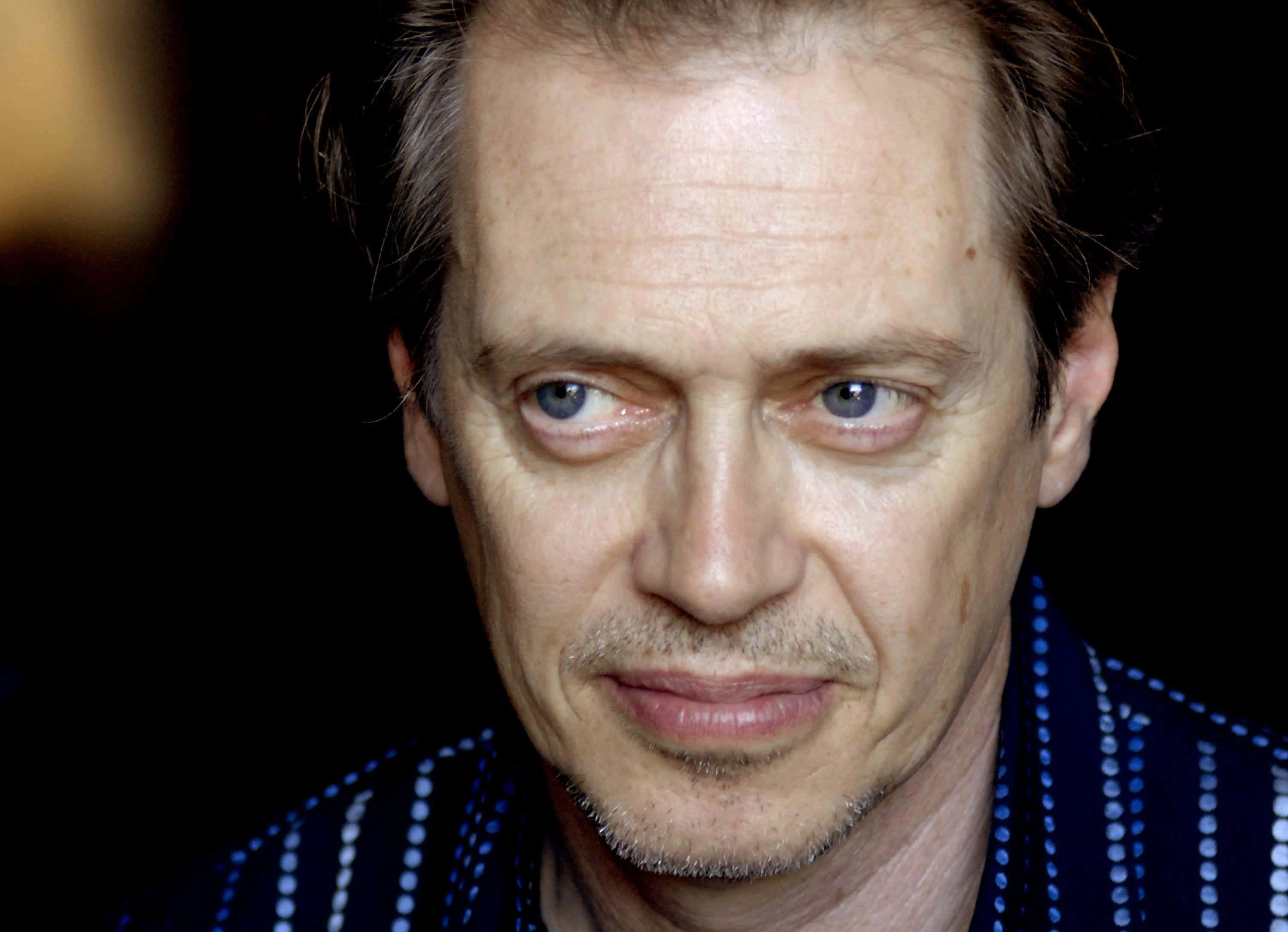 steve buscemi 桌布 壁紙 — 近距離肖像照，一名男子擁有強烈的藍色眼睛和嚴肅的表情，背景為深色。