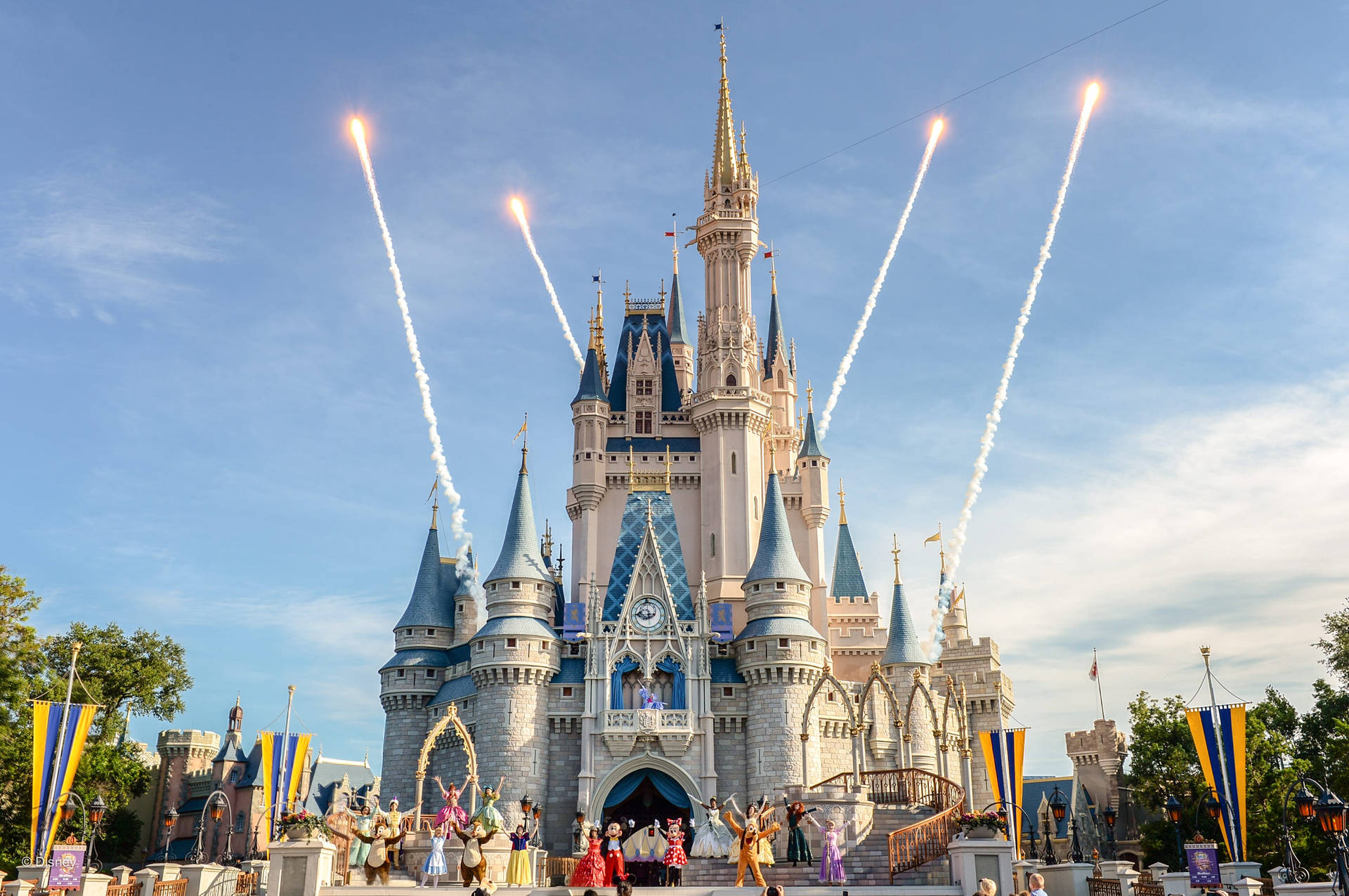 Castle 桌布 壁紙 — 迪士尼城堡在白天慶祝活動中，煙火向著晴朗的藍天發射。