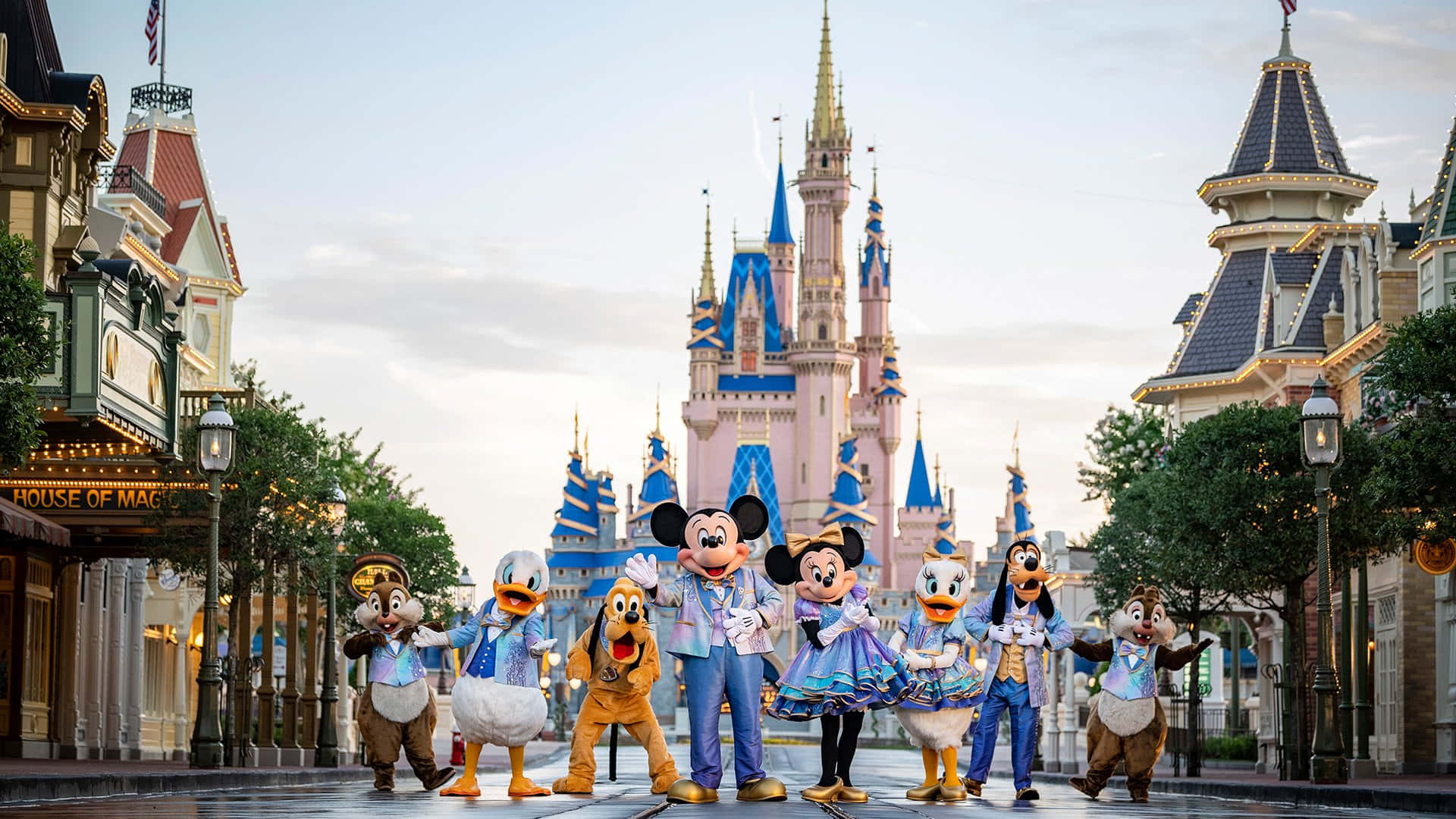 1920x1080 Disney 桌布 壁紙 — 迪士尼角色穿著協調的服裝，在黃昏時分於灰姑娘城堡前愉快地擺姿勢。