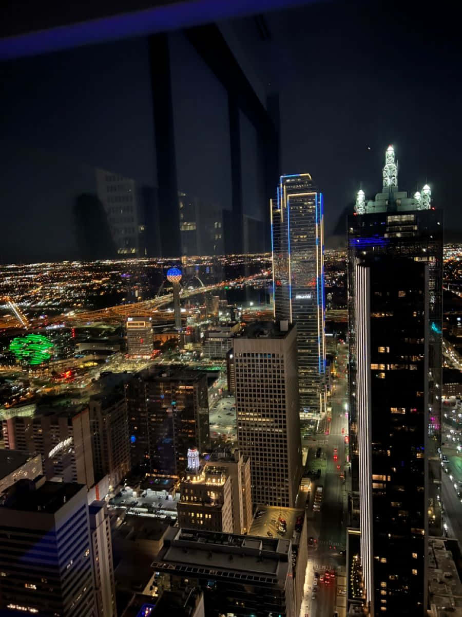 Building 桌布 壁紙 — 迷人的夜景城市景觀，高聳的摩天大樓閃爍著霓虹燈光，下方是廣闊的城市網格。