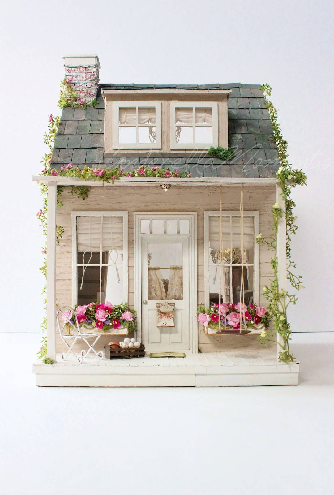 Dollhouse 桌布 壁紙 — 迷人的微型小屋，灰色木瓦屋頂，粉紅色花朵點綴門廊和窗台。
