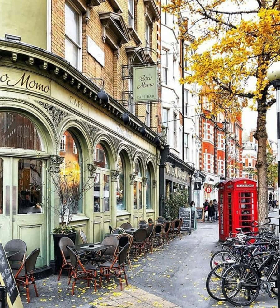 England 桌布 壁紙 — 迷人的秋日街景，設有復古咖啡館、紅色電話亭和金色樹葉下的自行車。