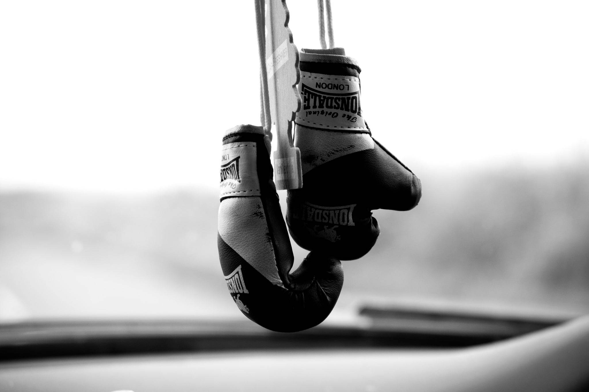 Boxing 桌布 壁紙 — 迷你拳擊手套用繩子掛在汽車的後視鏡上，一張清晰的黑白照片。