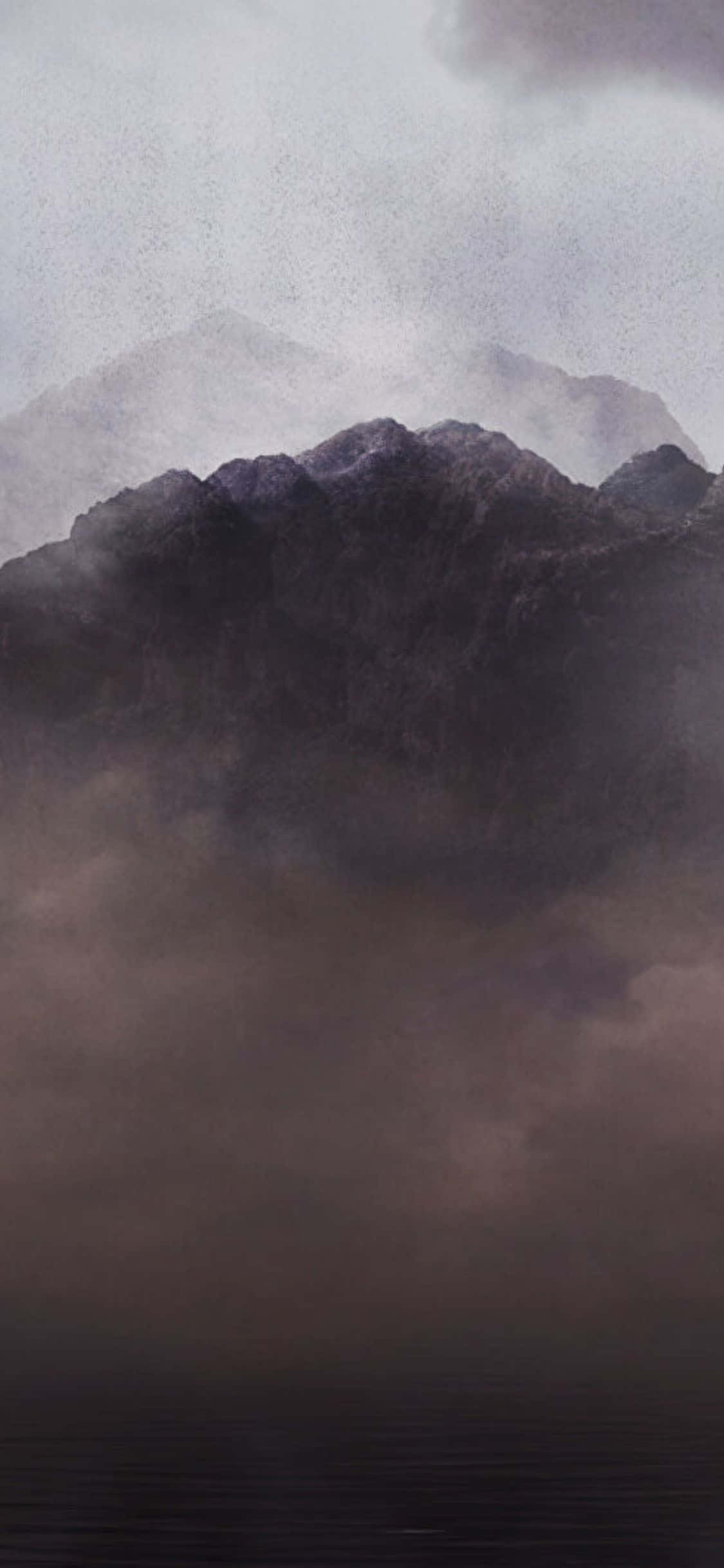 iPhone Xs Dawn Of War Iii 桌布 壁紙 — 迷霧山巒在旋轉的灰色雲層中升起，下方是陰沉天空下的黑暗水域。