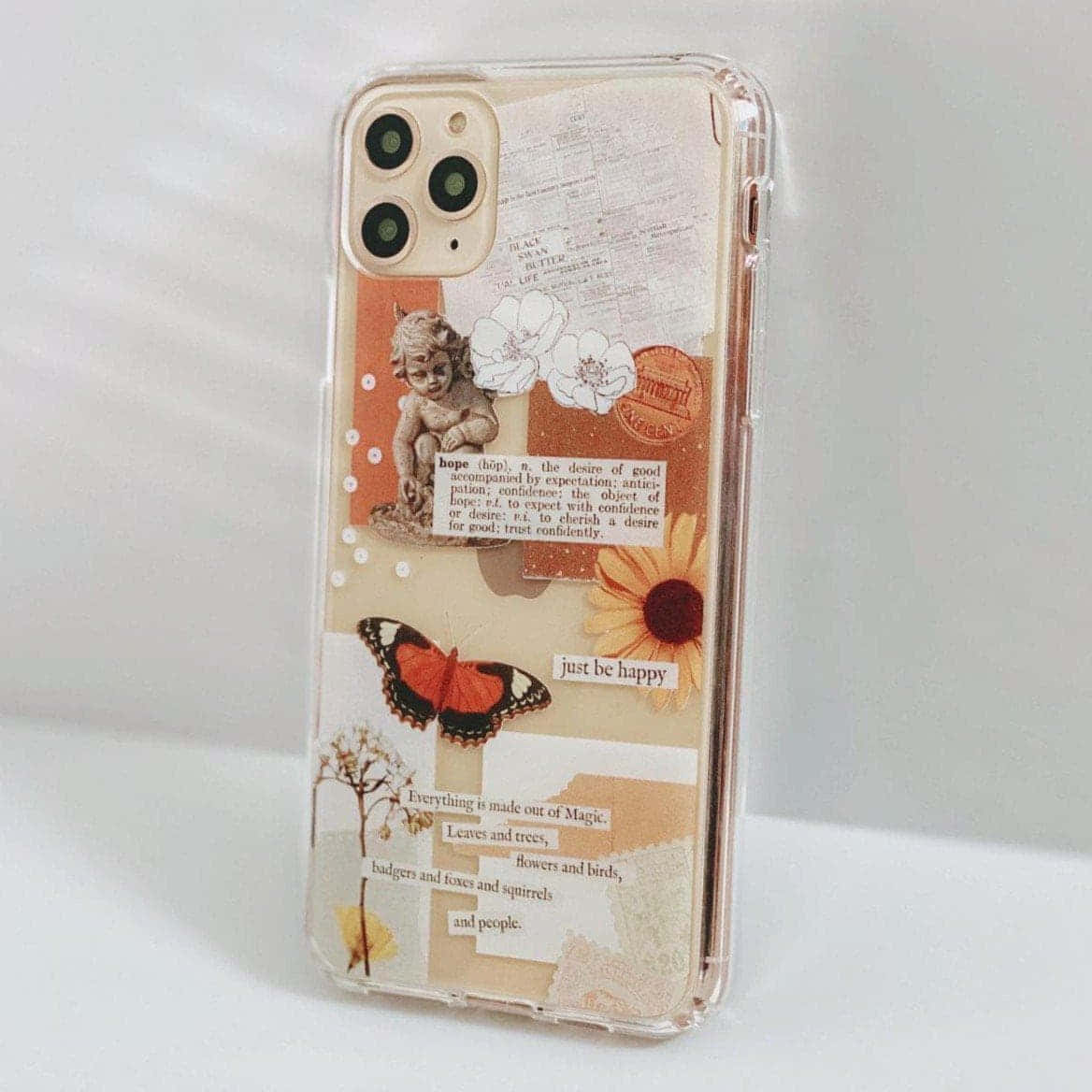 iPhone 美學 桌布 壁紙 — 透明手機殼，裝飾有復古拼貼元素，包括小天使、蝴蝶、向日葵和勵志語錄。