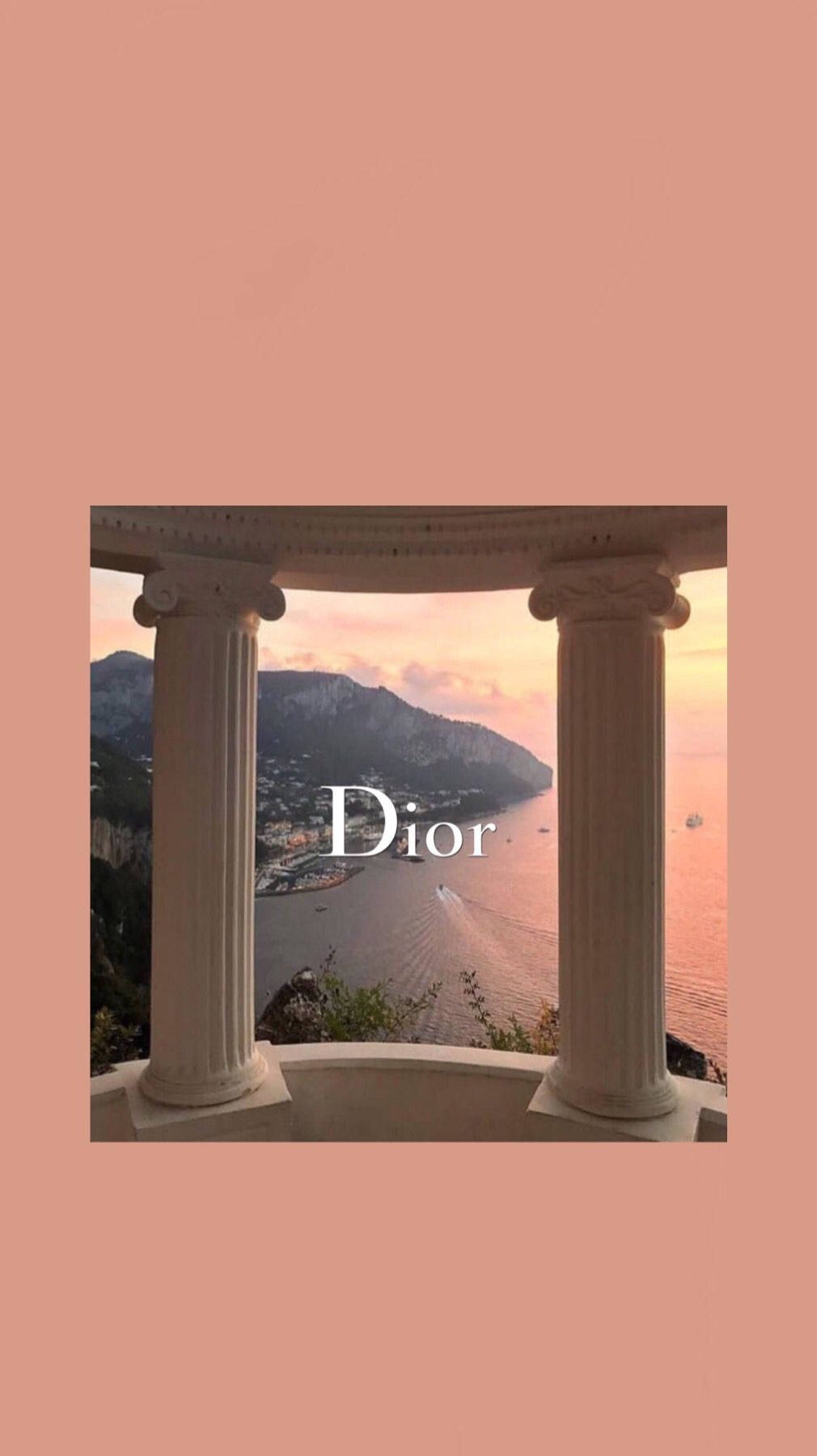 Dior 動態 桌布 壁紙 — 透過古典柱子的粉紅色框景觀，顯示日落時分的沿海城鎮，並疊加Dior標誌。
