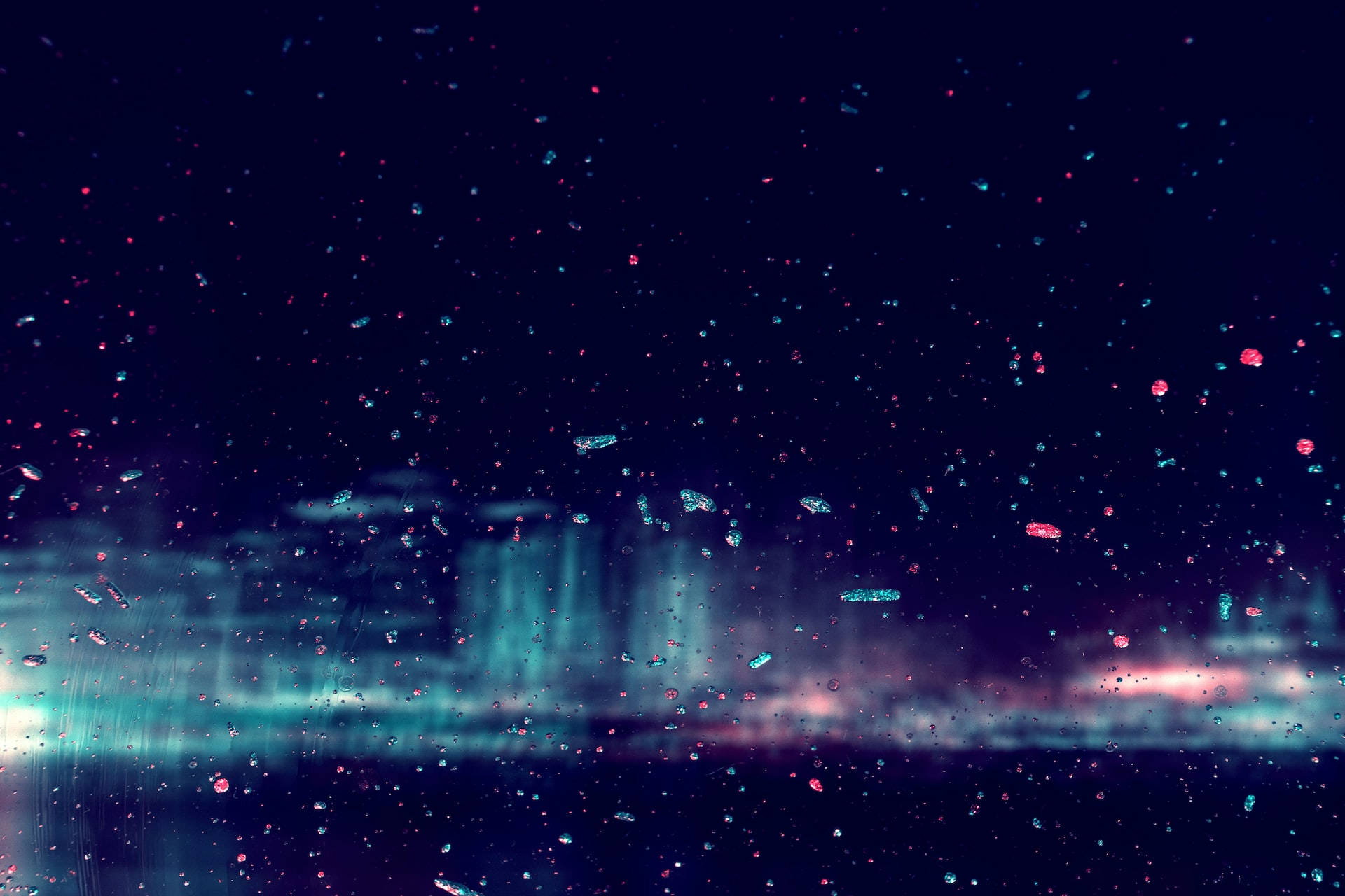 Night Aesthetic 桌布 壁紙 — 透過濺滿雨水的玻璃觀看，迷人的北極光在黑暗的天空中舞動，伴隨著發光的霓虹粒子。