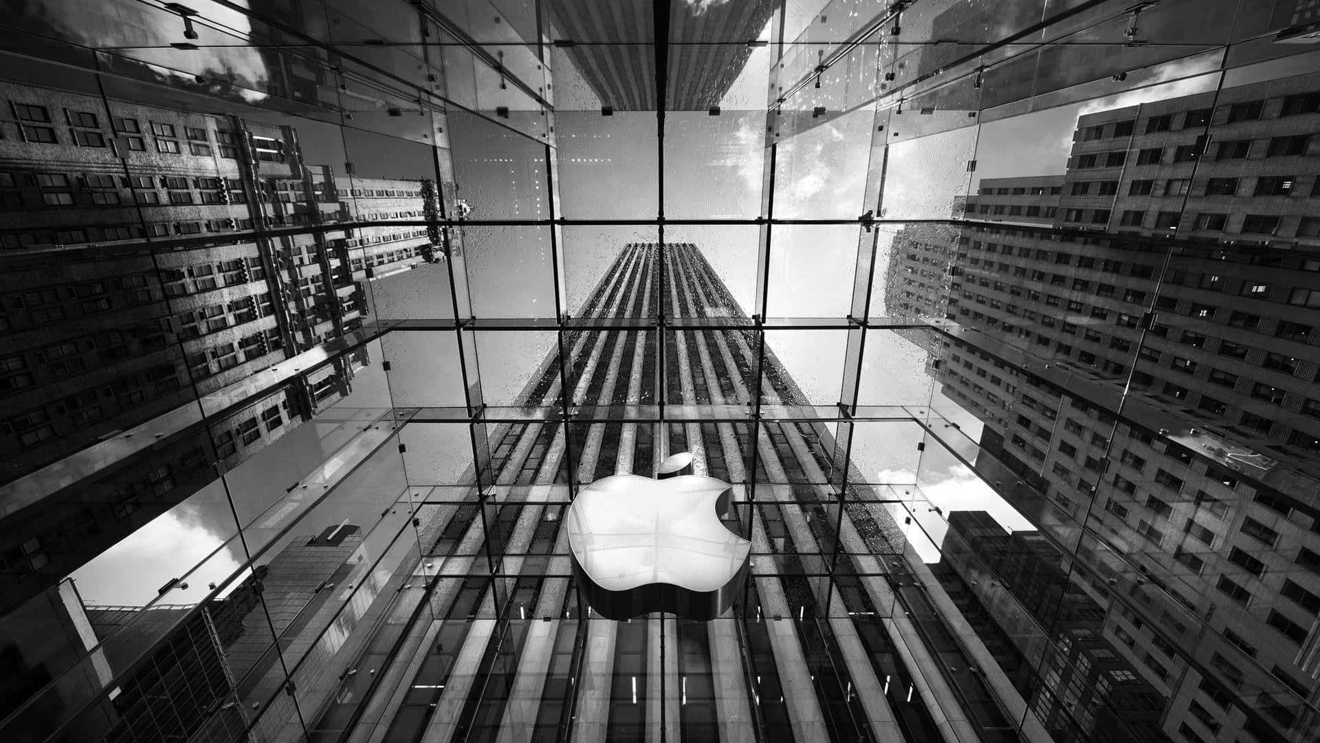 1920x1080 Apple 桌布 壁紙 — 透過玻璃天花板向上看的黑白景色，顯示發光的Apple標誌位於鏡面摩天大樓之間的中心位置。