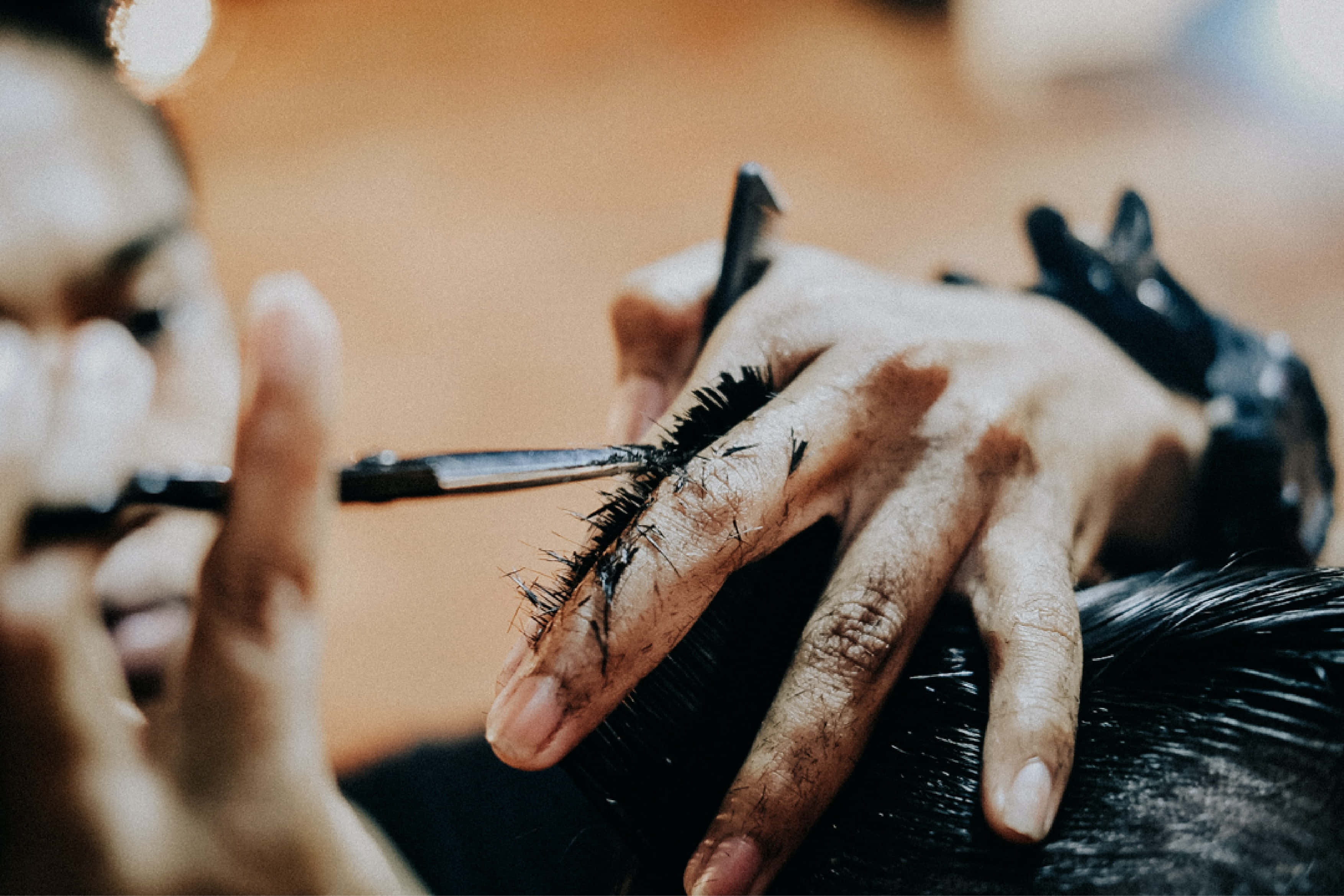 Barber 桌布 壁紙 — 造型師雙手使用精準工具為客戶頭部貼上深色假髮片的特寫。
