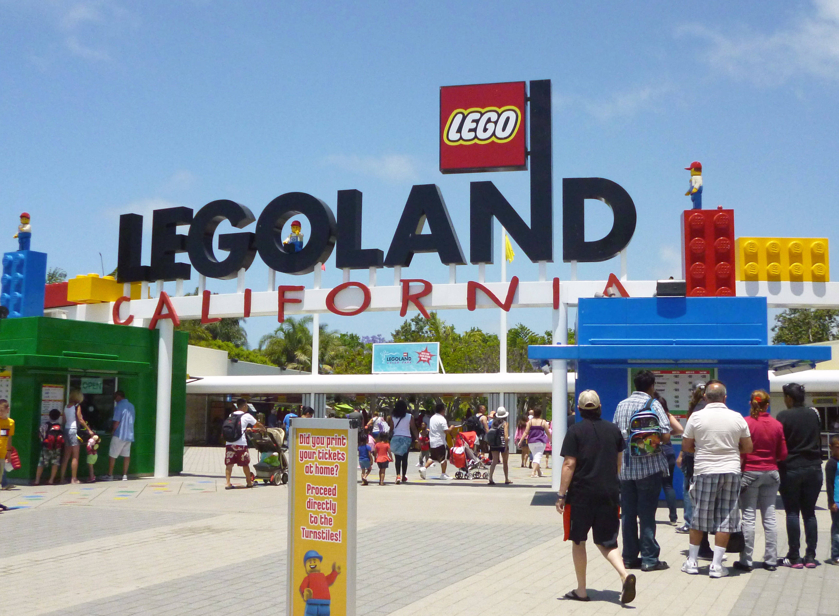 小孩動圖 桌布 壁紙 — 遊客在晴朗的藍天下聚集在LEGOLAND California色彩繽紛的LEGO主題入口處。