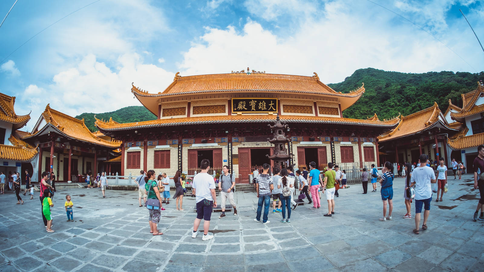 Shenzhen 桌布 壁紙 — 遊客探索一座宏偉的傳統中式寺廟，擁有金色屋頂和紅色柱子，在明亮的藍天下。