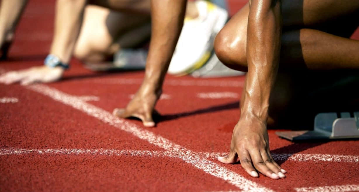 track 桌布 壁紙 — 運動員在帶有白線的紅色跑道上準備起跑，蓄勢待發。