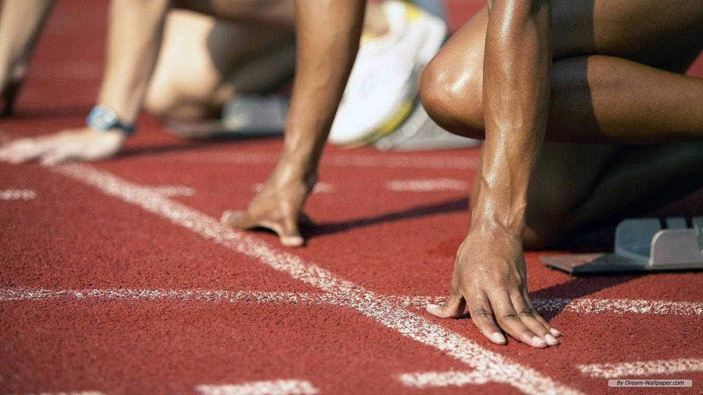 運動 桌布 壁紙 — 運動員在白色線條的紅色跑道上，於明亮的日光下準備就緒的起跑架上。