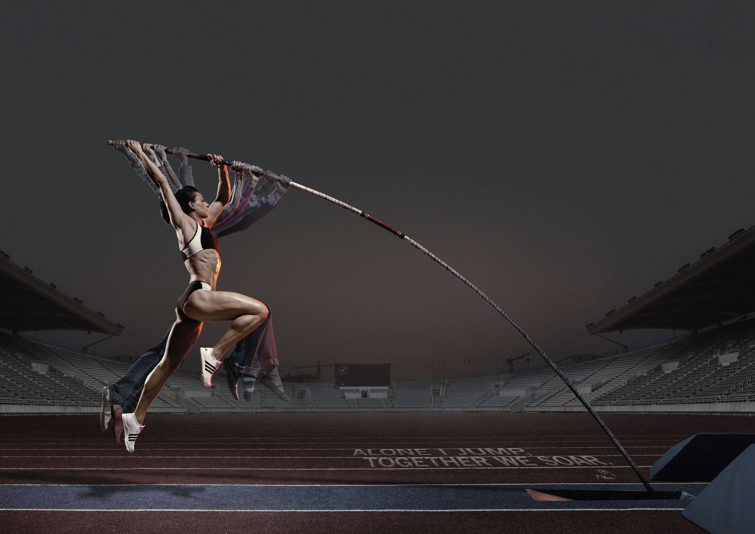 Athletic 桌布 壁紙 — 運動員在空蕩蕩的體育館中進行撐竿跳，戲劇性的燈光和跑道上激勵人心的文字。