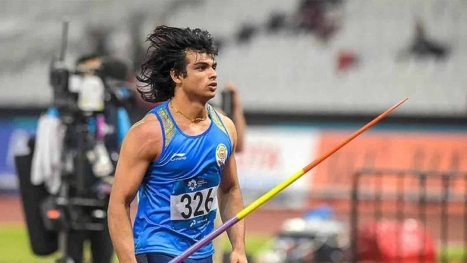 Athletic 桌布 壁紙 — 運動員頭髮被風吹起，在體育場燈光下於跑道上握著標槍邁步。