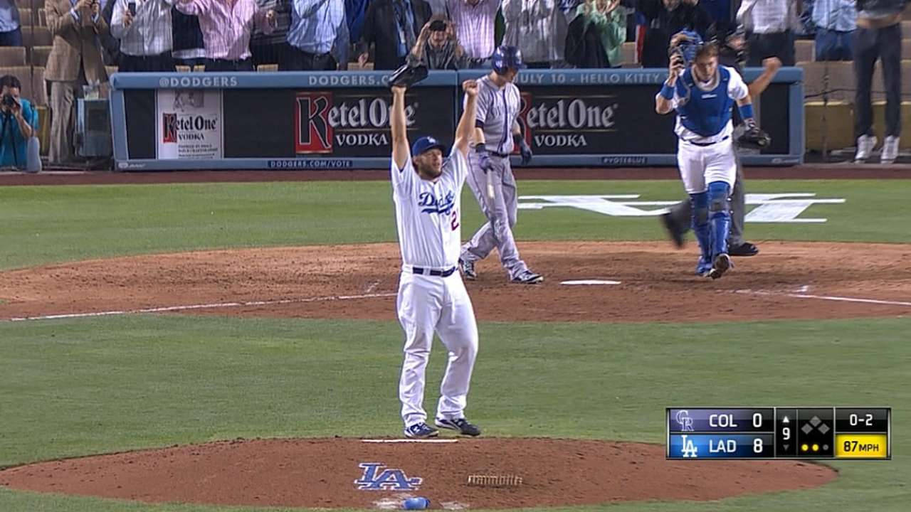 MLB 桌布 壁紙 — 道奇隊投手在投手丘上高舉雙臂慶祝，捕手和打者在夜間棒球比賽中作出反應。
