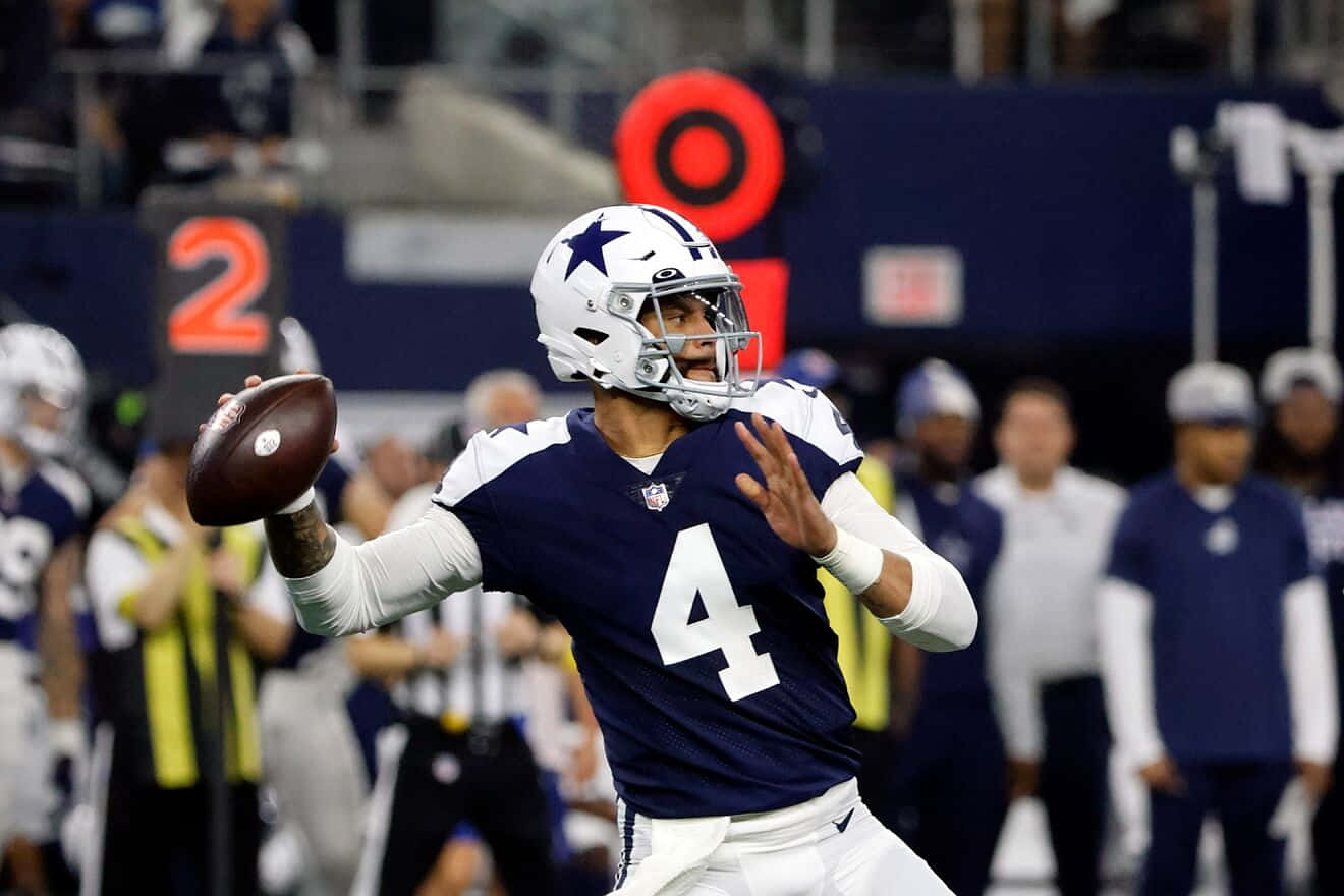 Dallas Cowboys Players 桌布 壁紙 — 達拉斯牛仔隊四分衛達克·普雷斯科特身穿海軍藍4號球衣，在夜間比賽中於體育場燈光下擲出橄欖球。