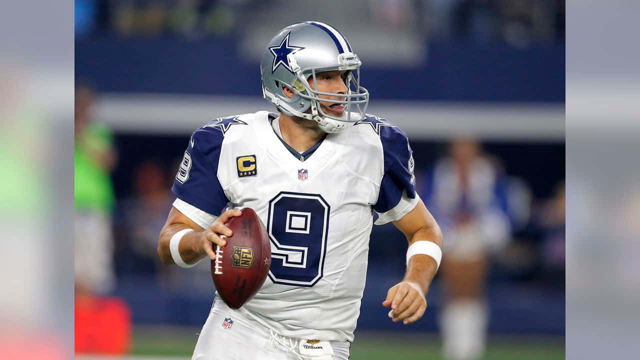 NFL 桌布 壁紙 — 達拉斯牛仔隊四分衛達克·普雷斯科特身穿白色和藍色球衣，在球場上持球進行比賽。