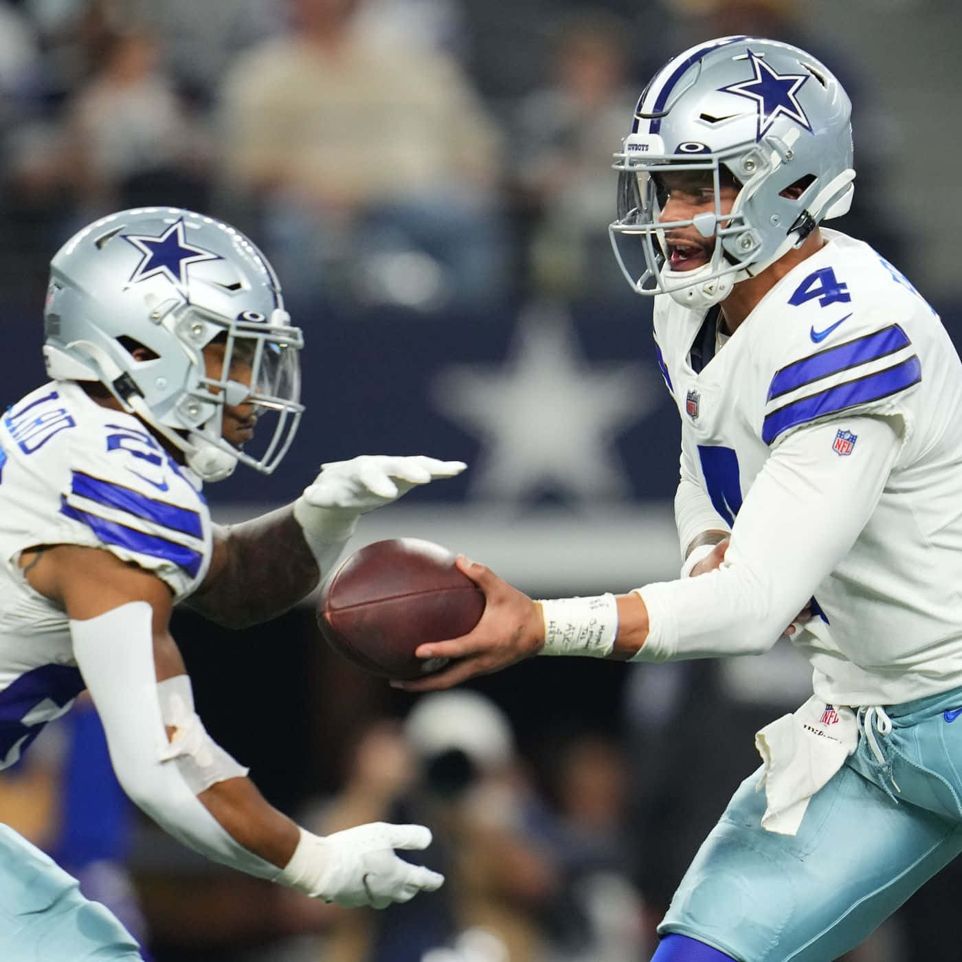 Dwayne Haskins 桌布 壁紙 — 達拉斯牛仔隊的四分衛在夜間比賽中，在體育場燈光下將橄欖球傳給隊友。