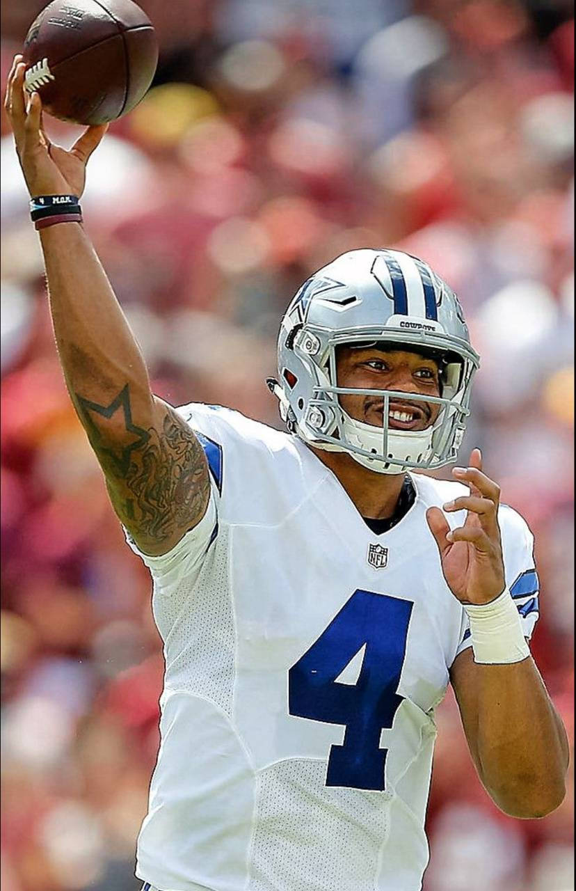Dak Prescott 桌布 壁紙 — 達拉斯牛仔隊的四分衛身穿白色4號球衣，在陽光明媚的日間比賽中準備投擲橄欖球。