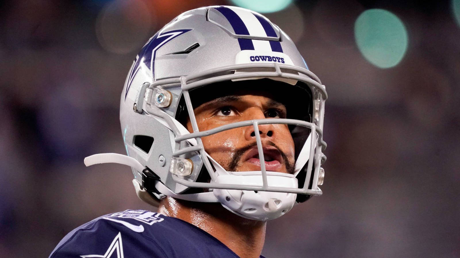 Dak Prescott 桌布 壁紙 — 達拉斯牛仔隊美式足球員戴頭盔，在球場燈光下表情專注的特寫。