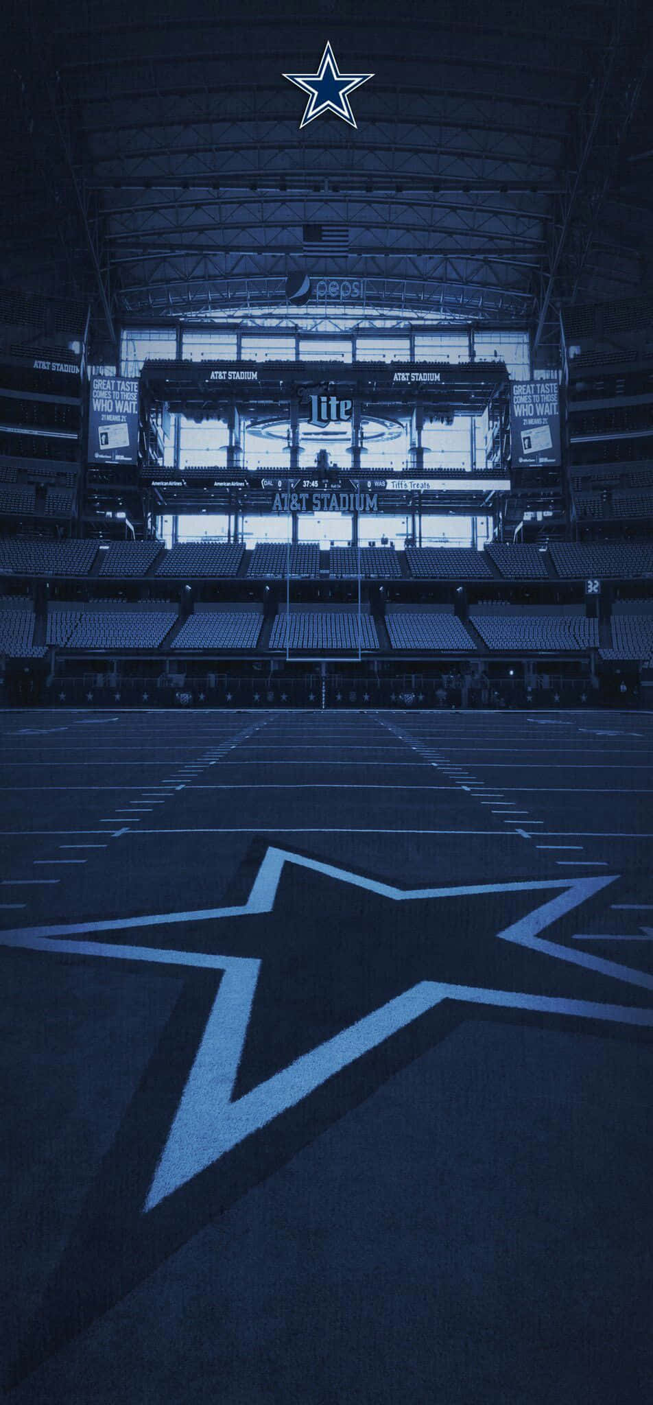 Dallas Cowboys iPhone 桌布 壁紙 — 達拉斯牛仔隊體育館內部光線昏暗，場地上有一個大型星形標誌，高天花板下空無一人。