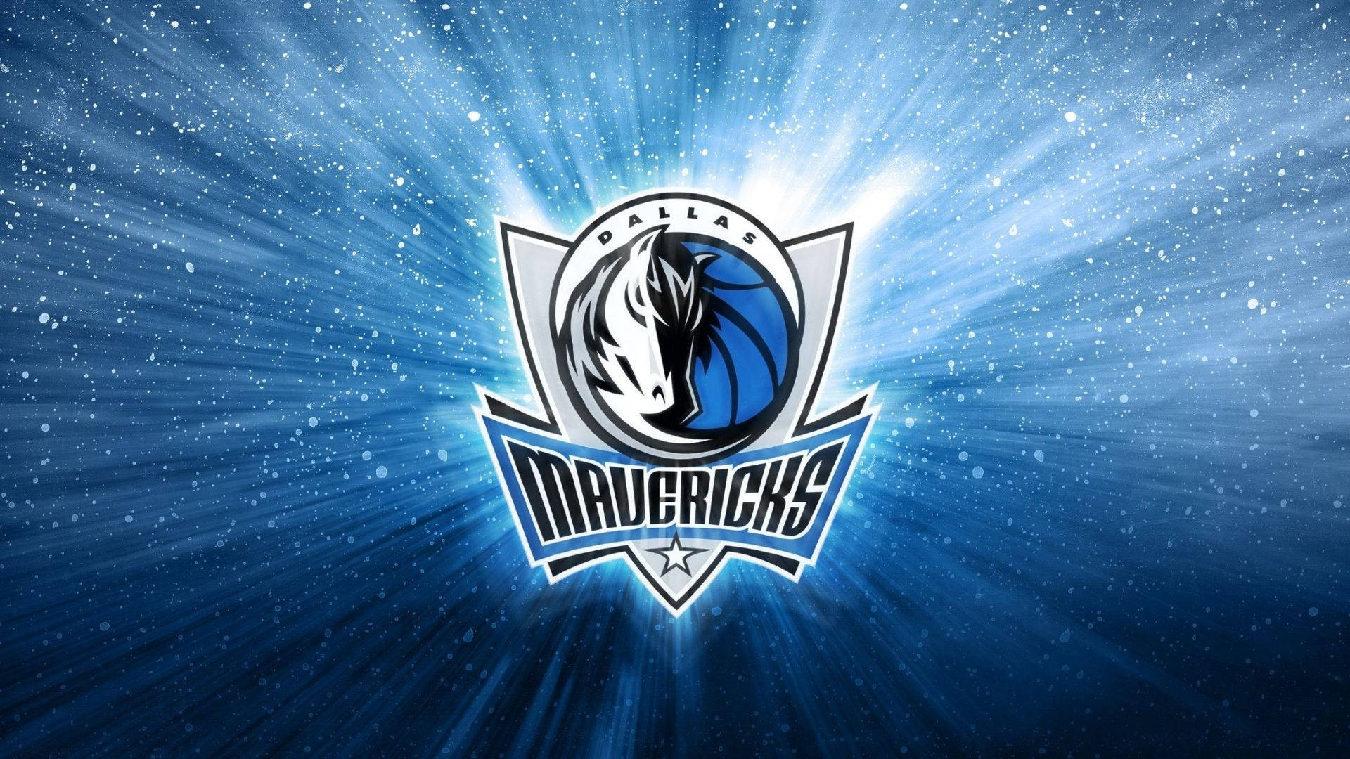 Mavericks 桌布 壁紙 — 達拉斯獨行俠標誌在深藍色星空背景上散發出明亮光芒，帶有動態光線。
