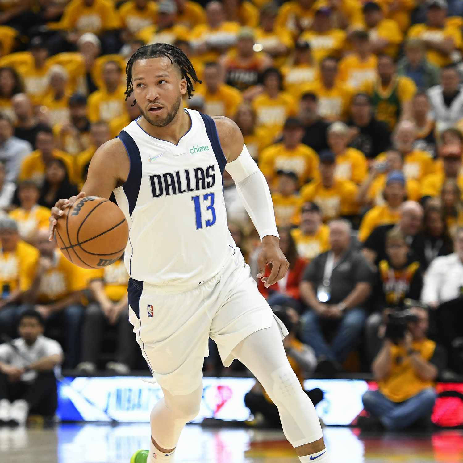 NBA 桌布 壁紙 — 達拉斯獨行俠籃球運動員在比賽中運球，身後有一群身穿黃色球衣的球迷。