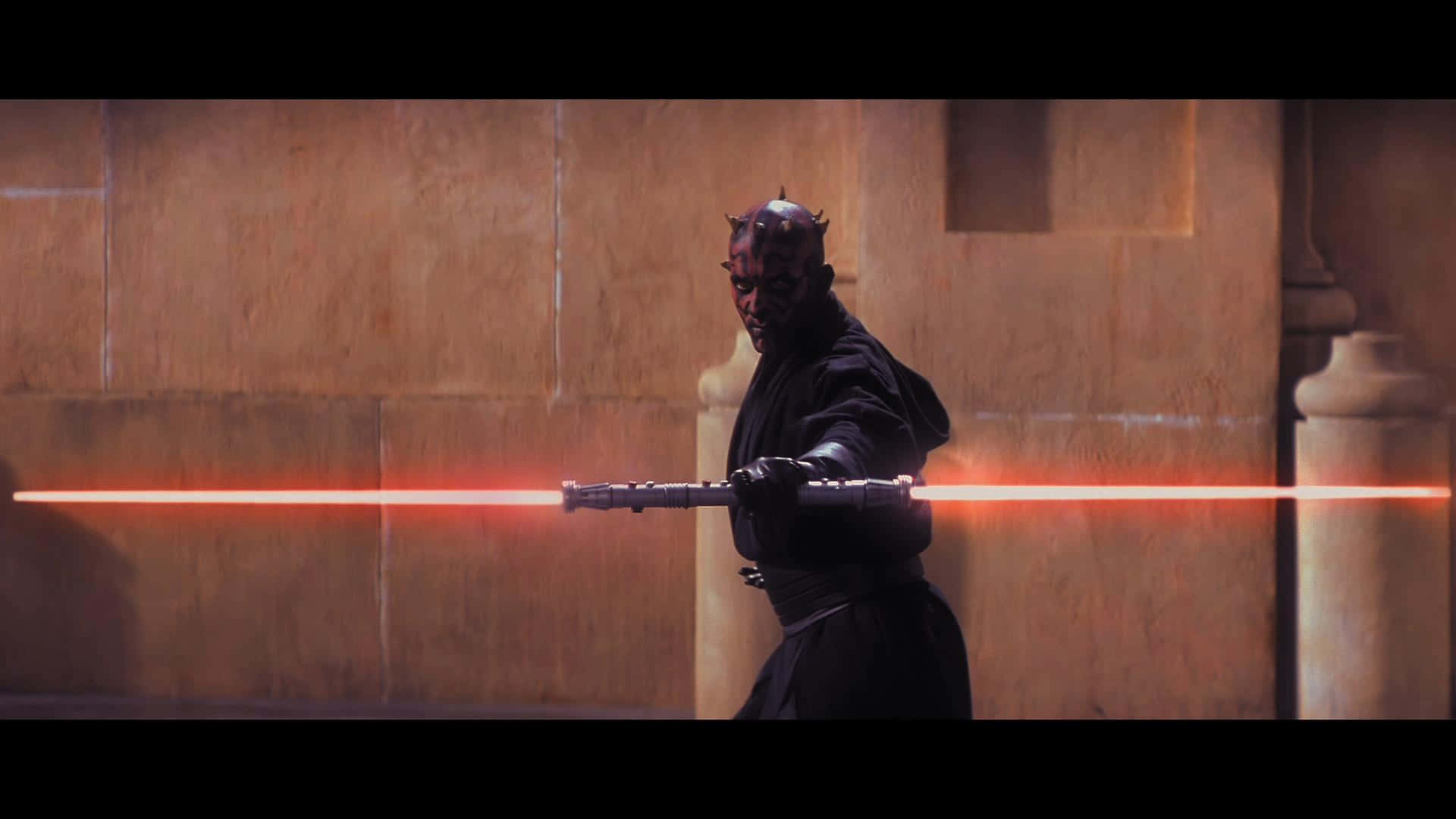 The Phantom Menace 桌布 壁紙 — 達斯摩爾在光線昏暗的石頭走廊中，手持雙刃紅色光劍，蓄勢待發。