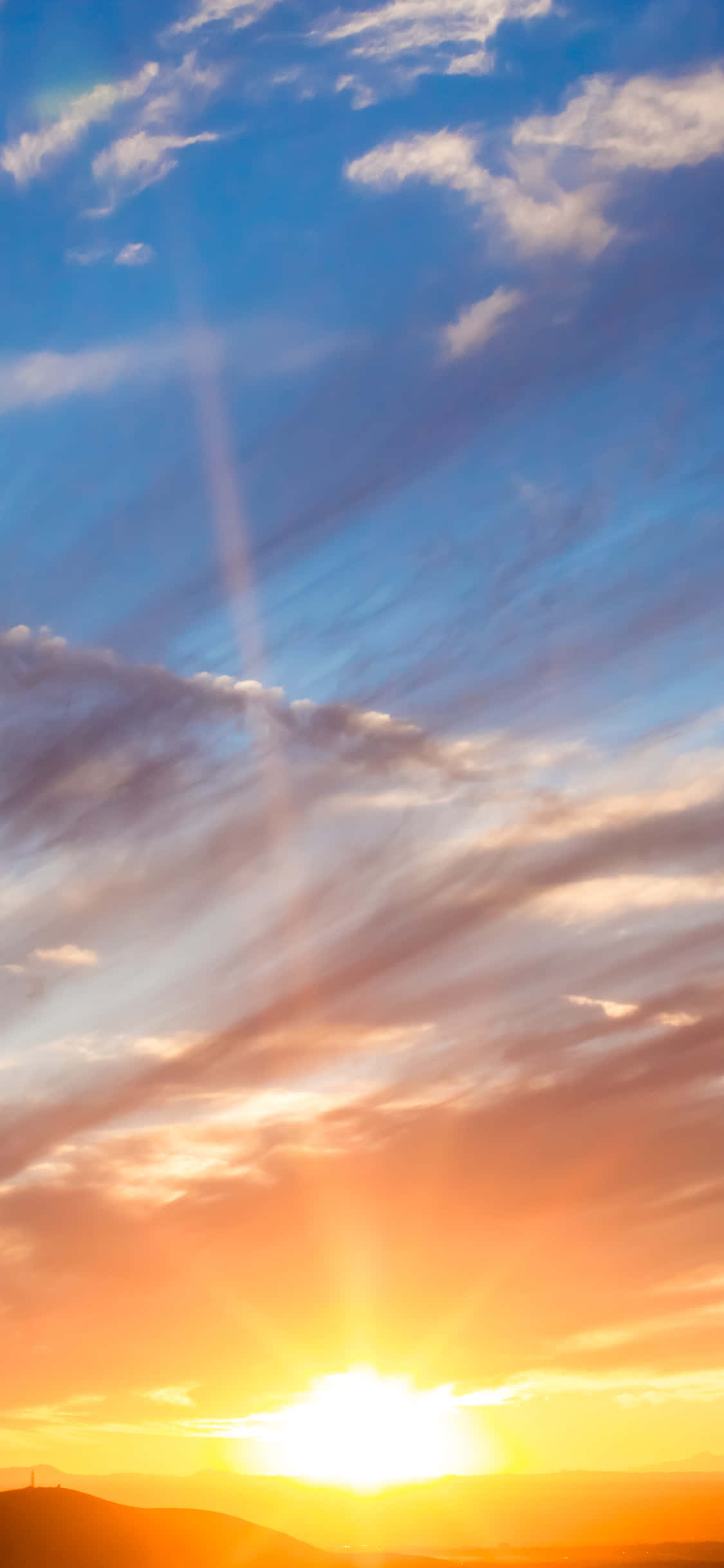 Sunrise iPhone 桌布 壁紙 — 遠山之上，橙藍雲層中透出金色陽光的燦爛日落。