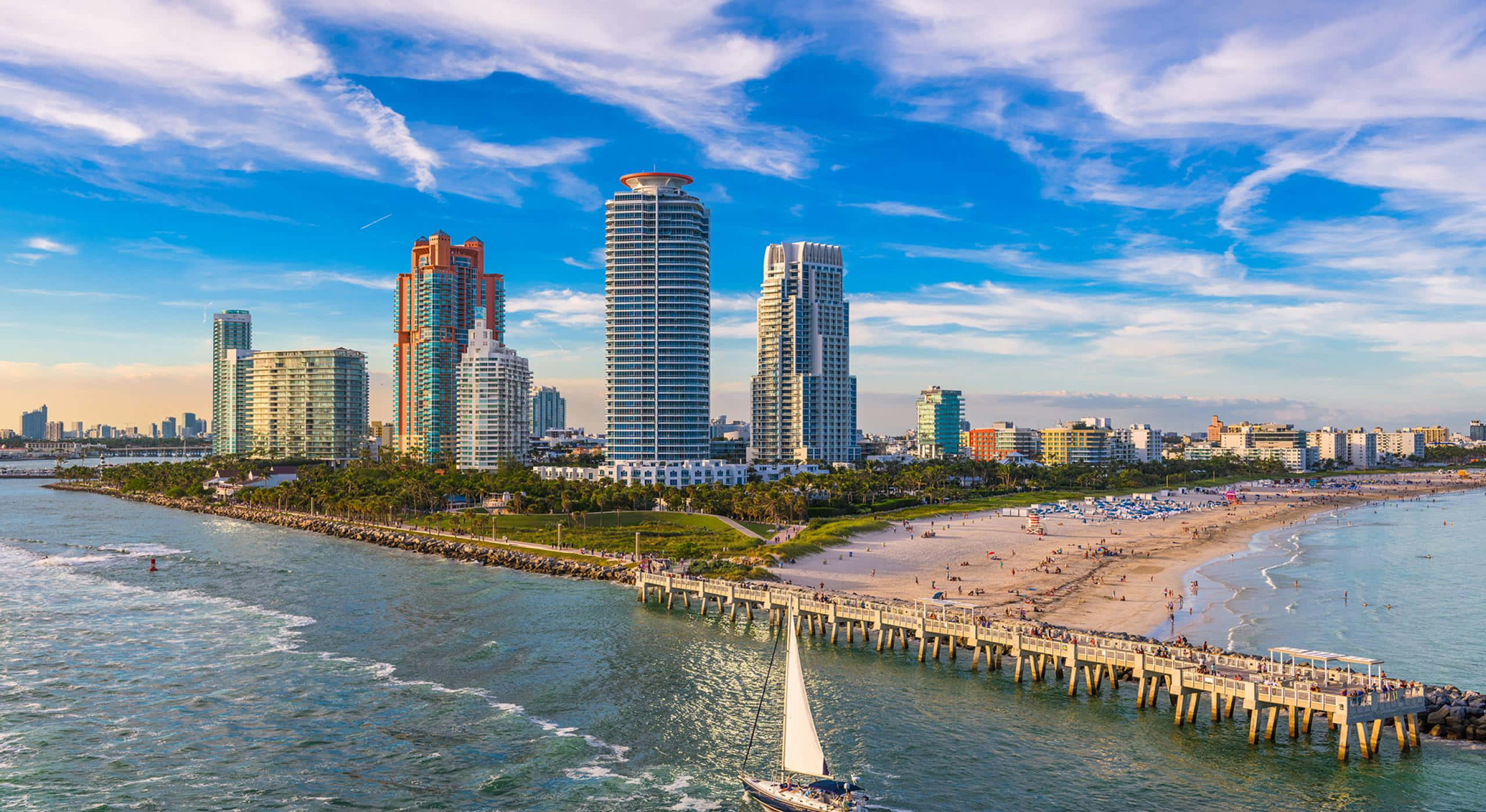 Miami 桌布 壁紙 — 邁阿密海灘的航拍圖，帆船在碼頭和摩天大樓旁滑行，天空湛藍。