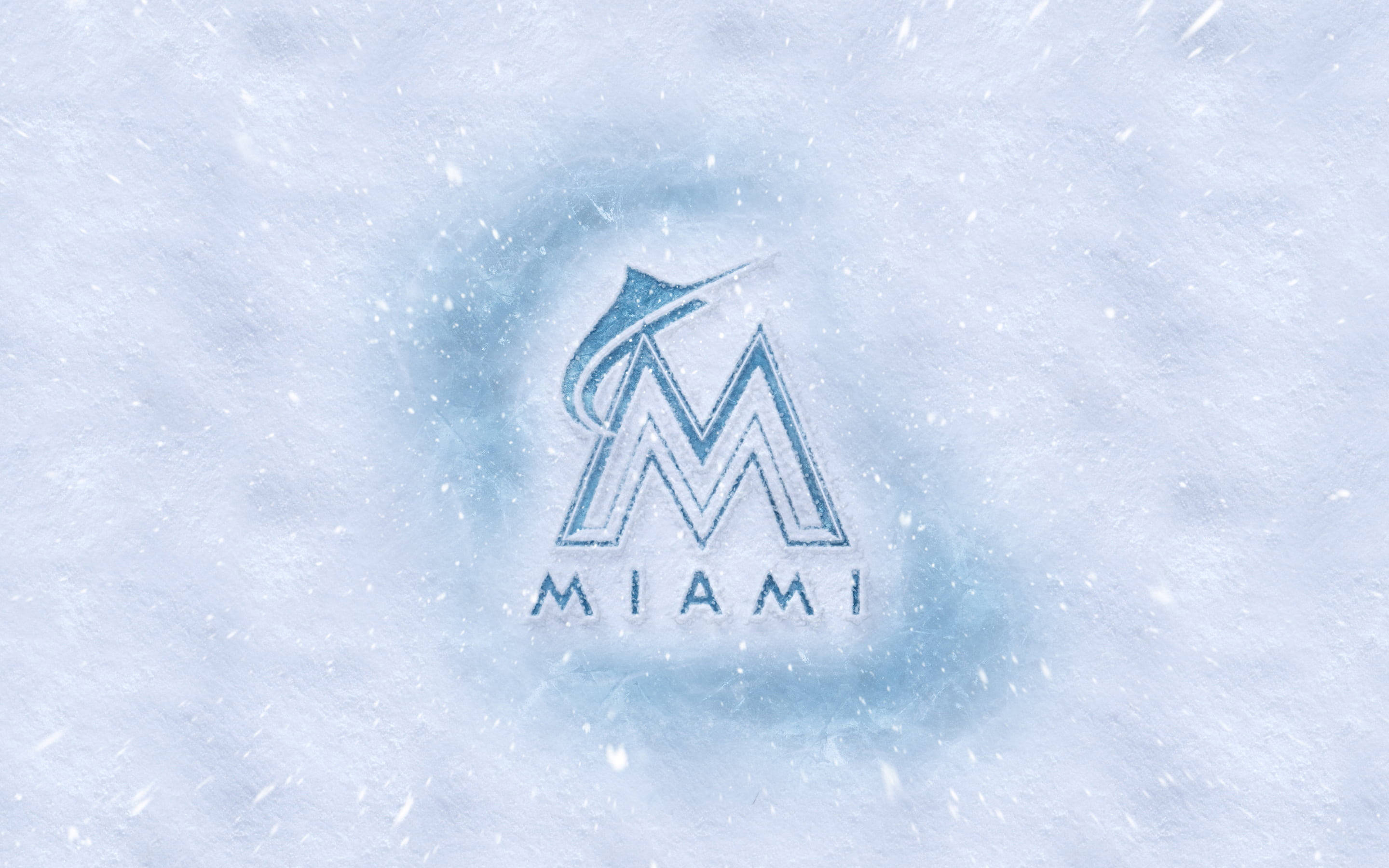 Marlins 桌布 壁紙 — 邁阿密馬林魚標誌刻在雪中，雪花在標誌周圍飄落旋轉。