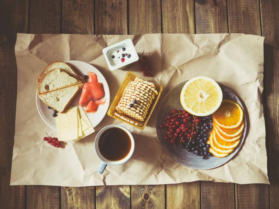 Fruits 桌布 壁紙 — 鄉村風早餐，鬆餅、莓果、柑橘和咖啡擺放在木桌上皺巴巴的牛皮紙上。