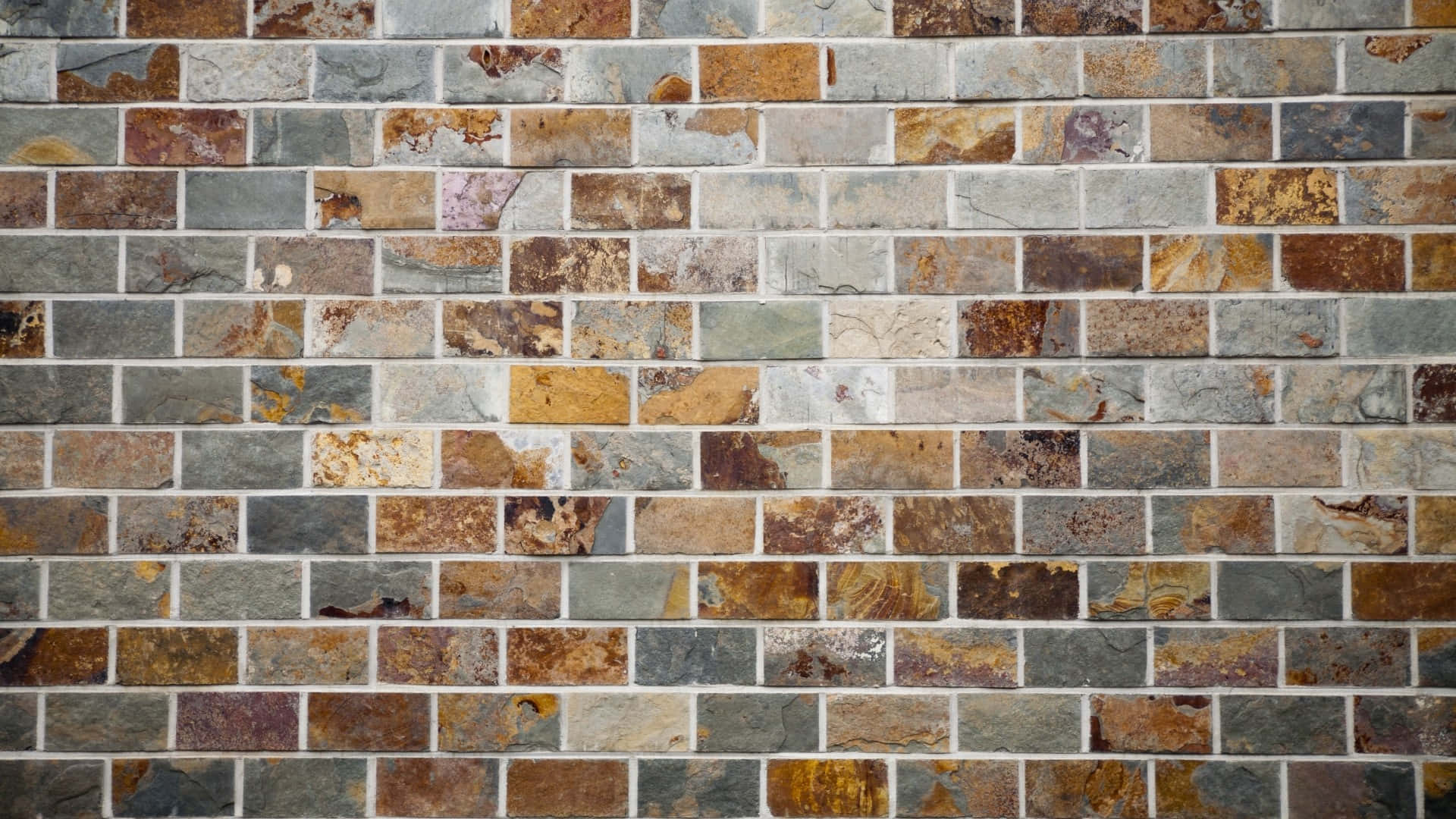 Tiles 桌布 壁紙 — 鄉村風格石磚牆的特寫，帶有大地色調和各種自然紋理，以磚塊圖案排列。