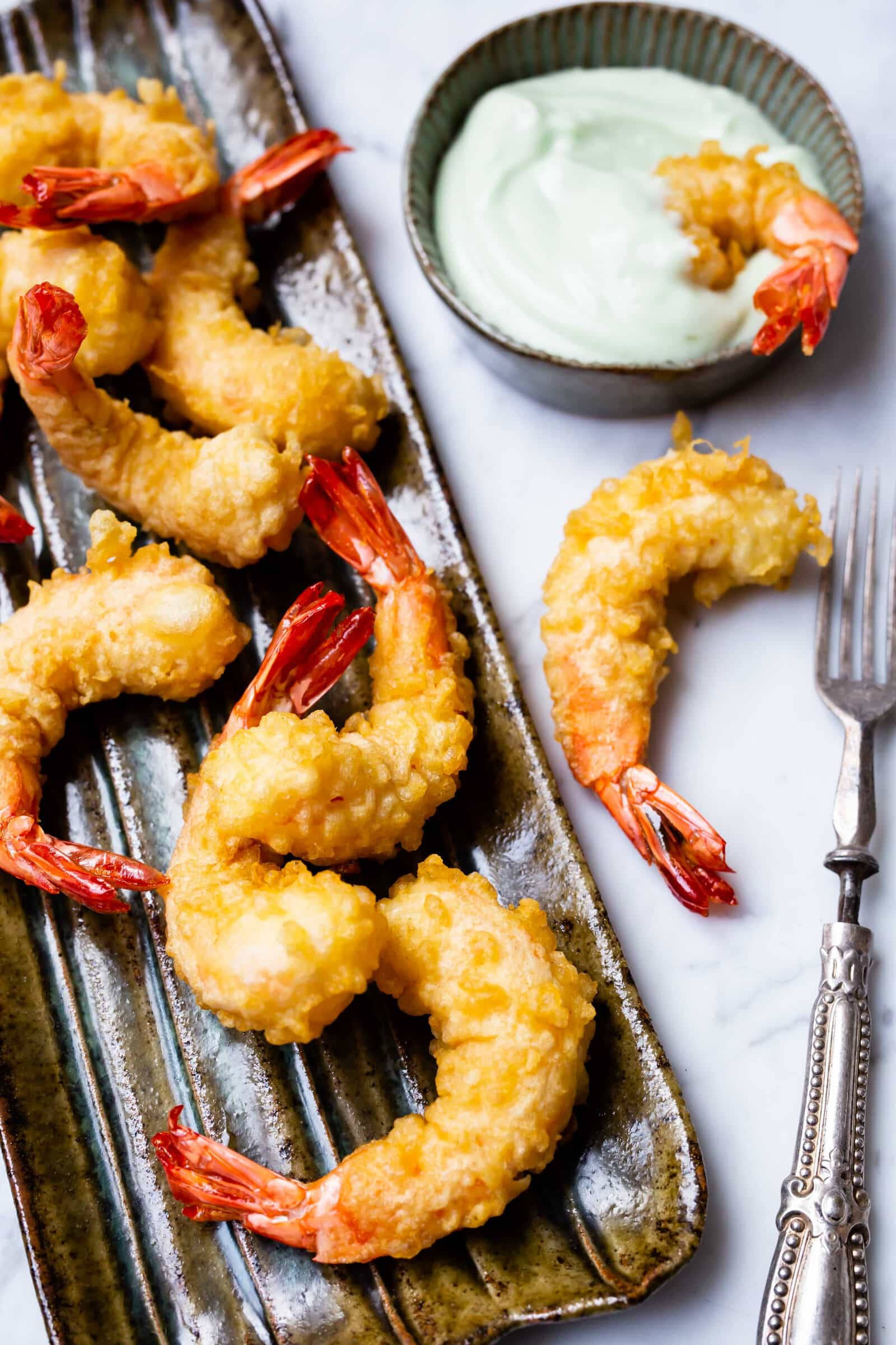 shrimp 桌布 壁紙 — 酥脆金黃天婦羅蝦（紅尾）擺放在深色陶瓷盤上，旁邊有奶油綠色蘸醬和裝飾叉。