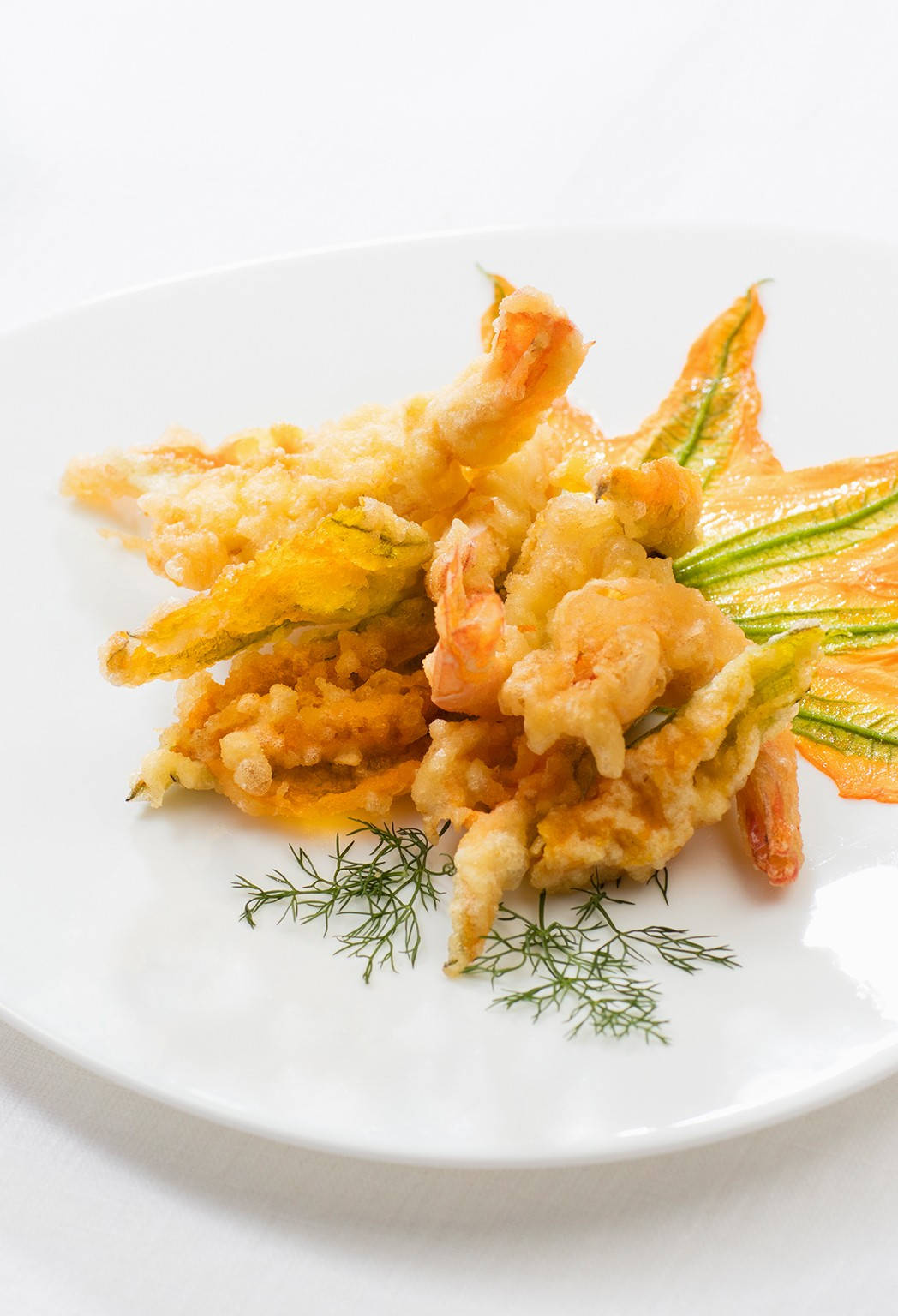 shrimp 桌布 壁紙 — 酥脆金黃天婦羅蝦和南瓜花，配上新鮮蒔蘿，優雅地擺放在白色盤子上。