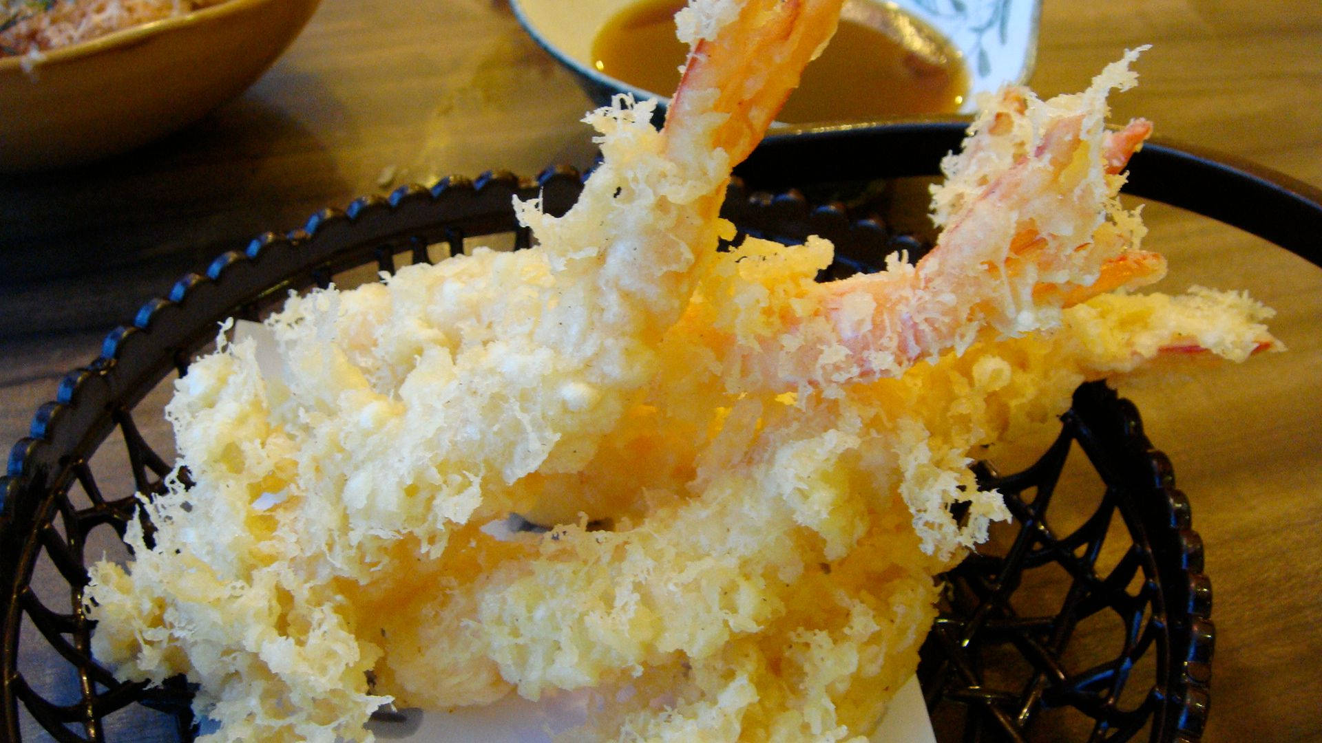 shrimp 桌布 壁紙 — 酥脆金黃的天婦羅蝦高高堆在木桌上的黑色鐵絲籃裡。