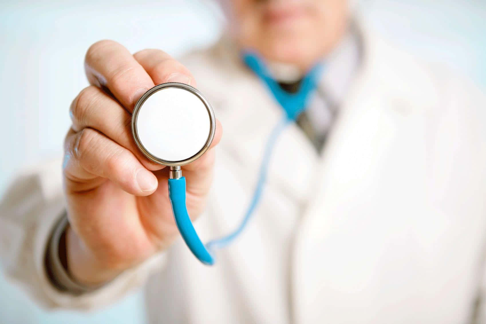 Stethoscope 桌布 壁紙 — 醫生手持聽診器的特寫，聽診器帶有亮藍色軟管，背景是模糊的白色醫生袍。