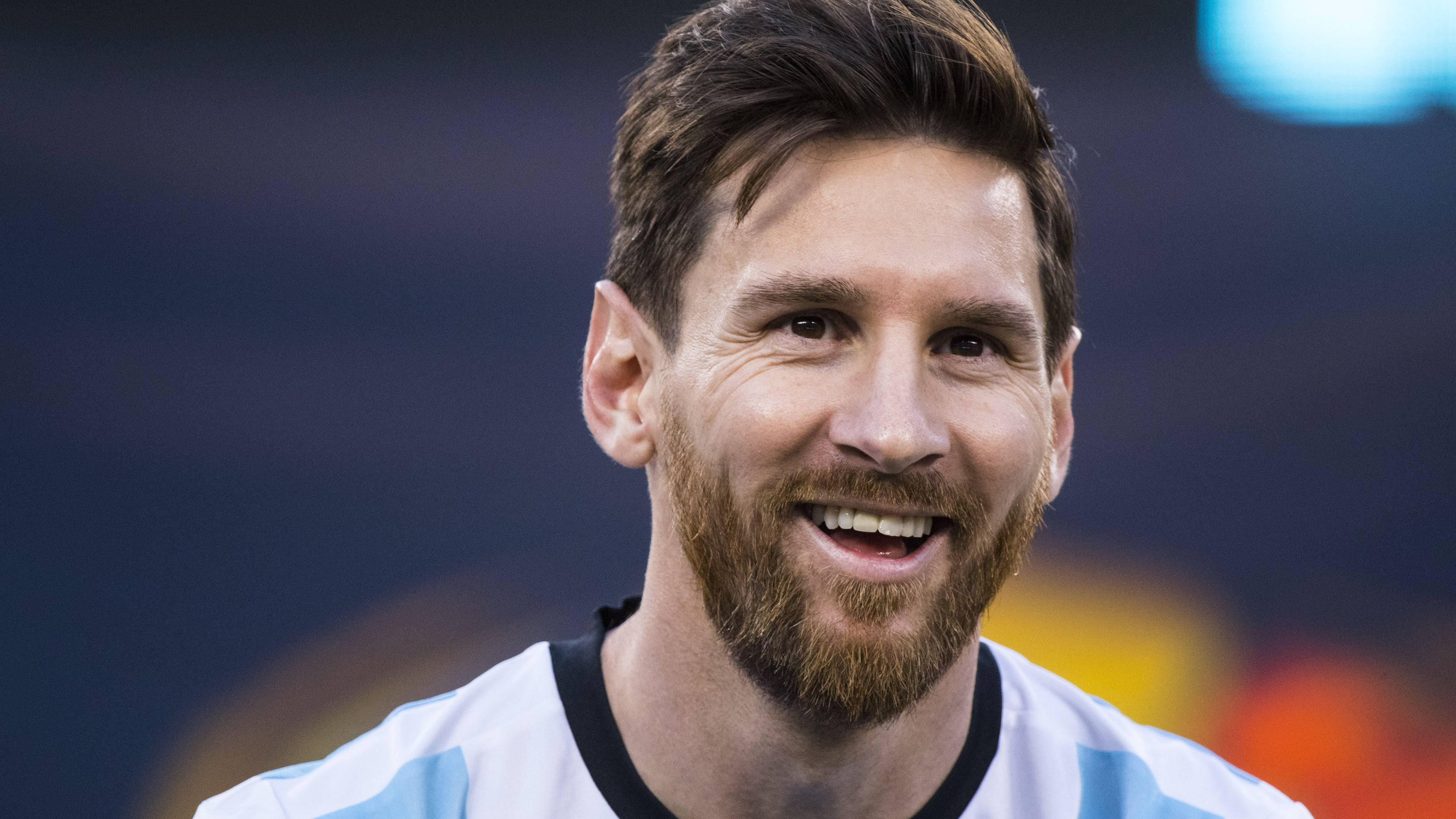 Messi 4K Ultra HD 桌布 壁紙 — 里奧內爾·梅西在球場燈光下身穿阿根廷藍白間條球衣溫暖微笑的特寫。